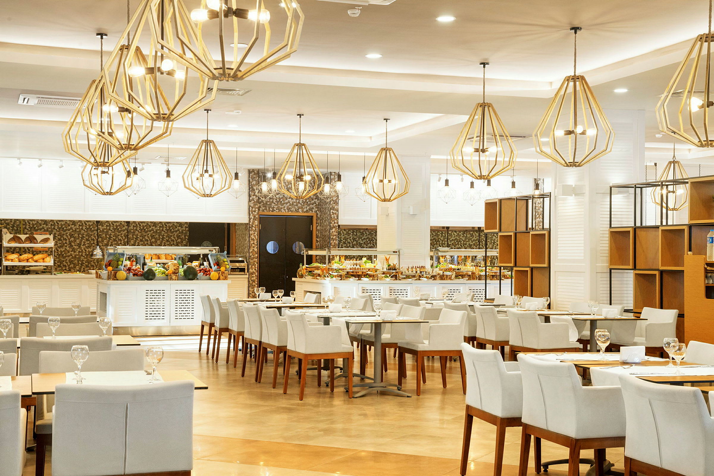 Interiör av en restaurang med dukade bord och ljuskronor i taket. (AI-genererad text)
