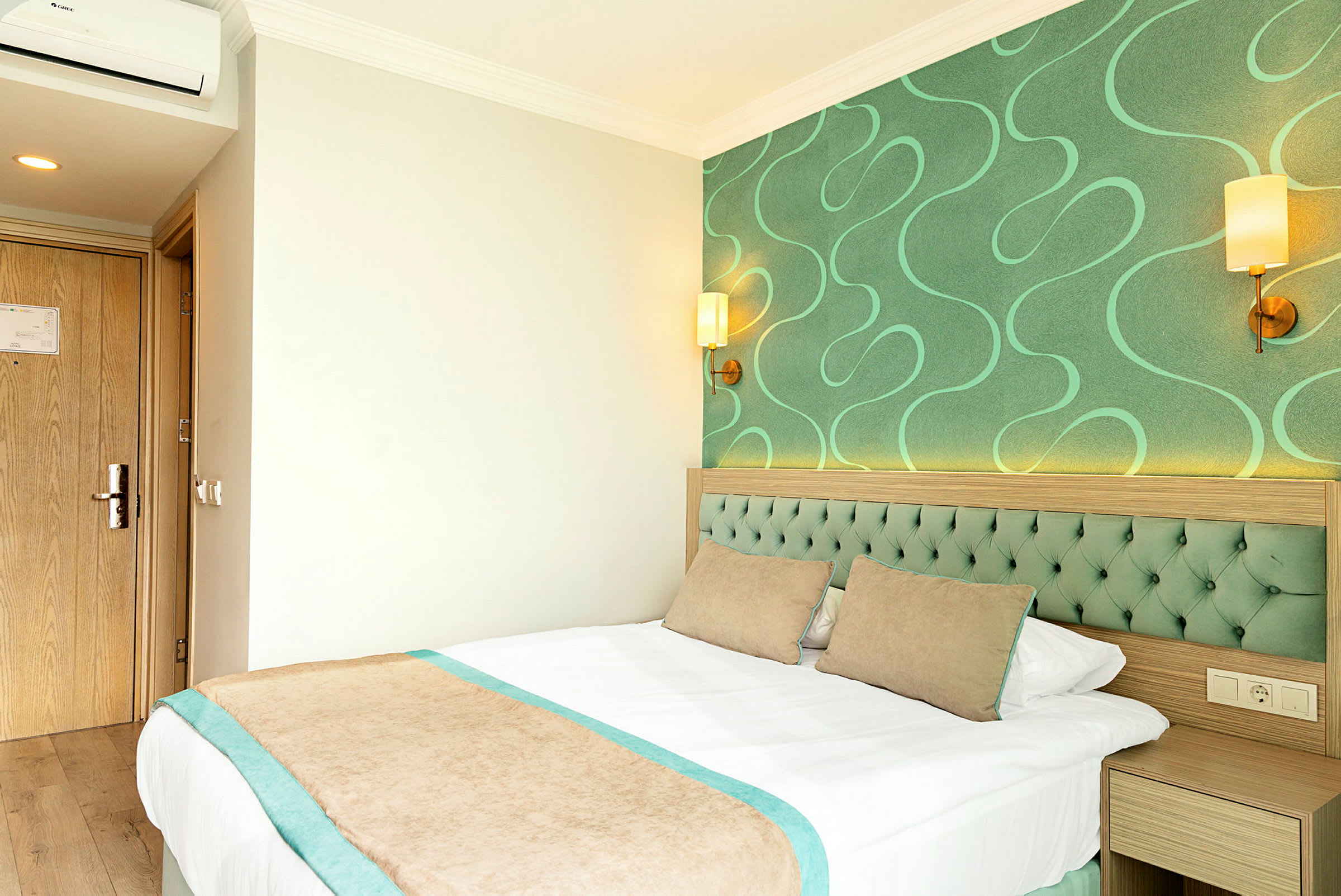 Hotellrum med gröna detaljer och en säng. (AI-genererad text)