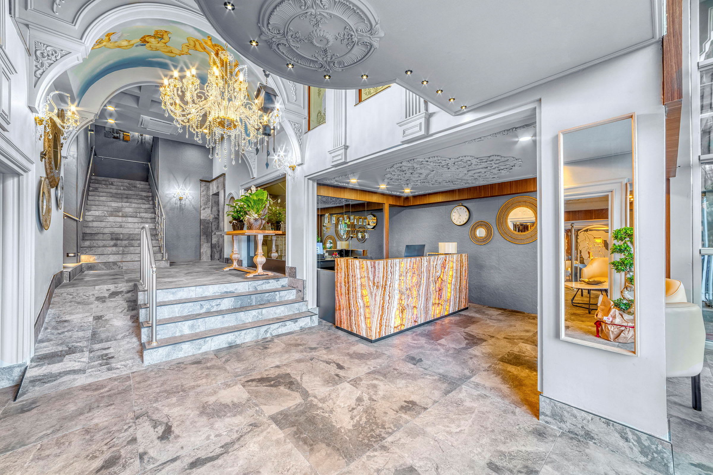 En hotellreception med elegant marmorgolv, en dekorerad kristallkrona och utsmyckade väggar. (AI-genererad text)