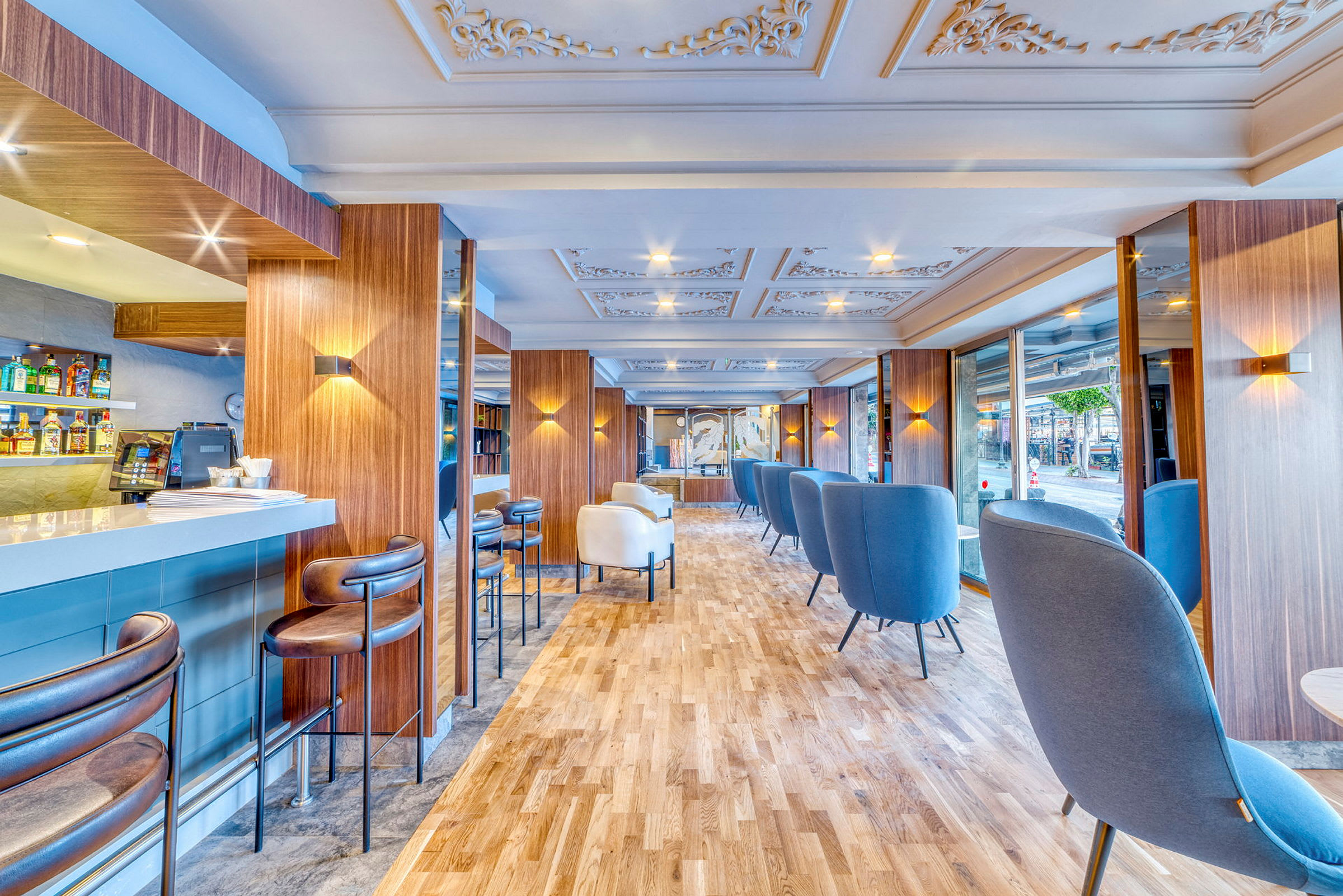 En modern inomhuslounge med blå och vita sittmöbler och ett barområde. (AI-genererad text)