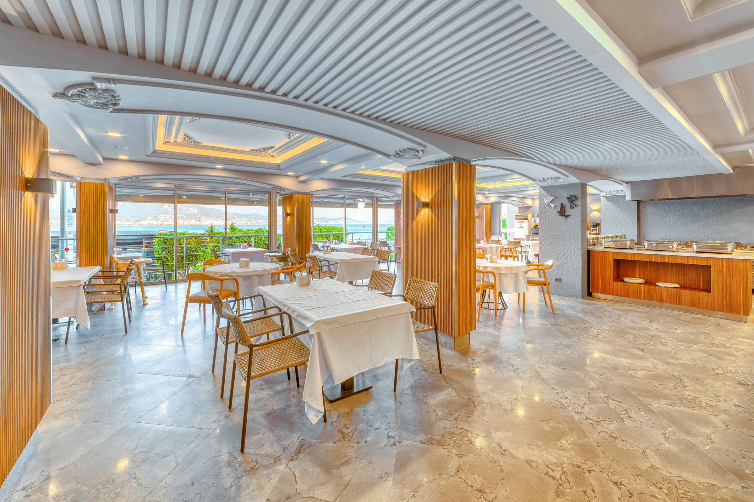 Restaurang med dukade bord, stolar och stora fönster med utsikt. (AI-genererad text)