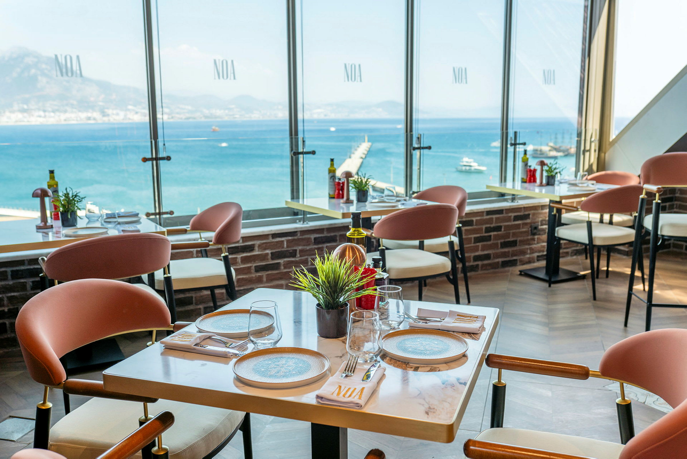 Restaurang med moderna möbler och utsikt över havet genom stora fönster. (AI-genererad text)