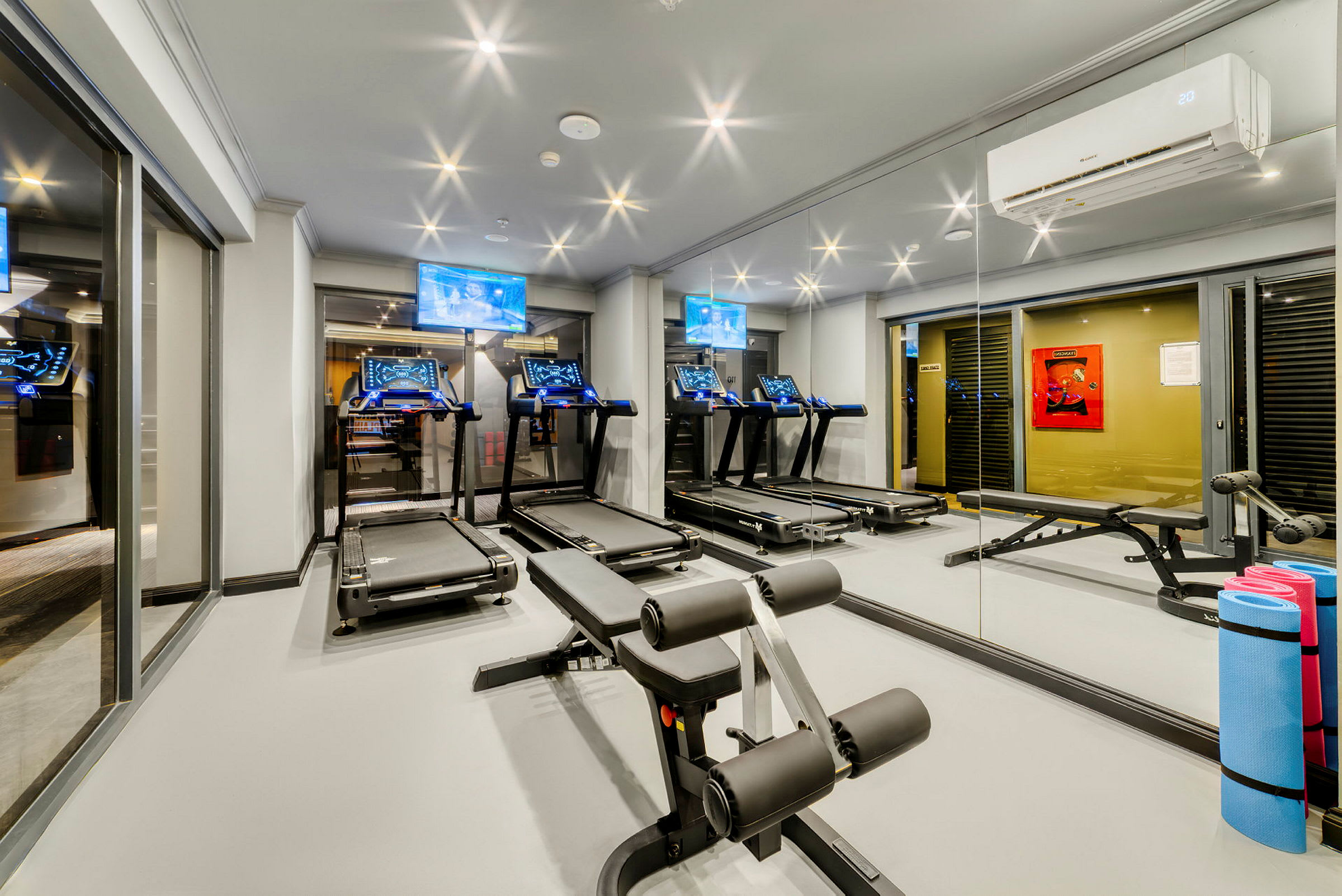 Ett gym med löpband, träningsbänk och andra träningsredskap. (AI-genererad text)