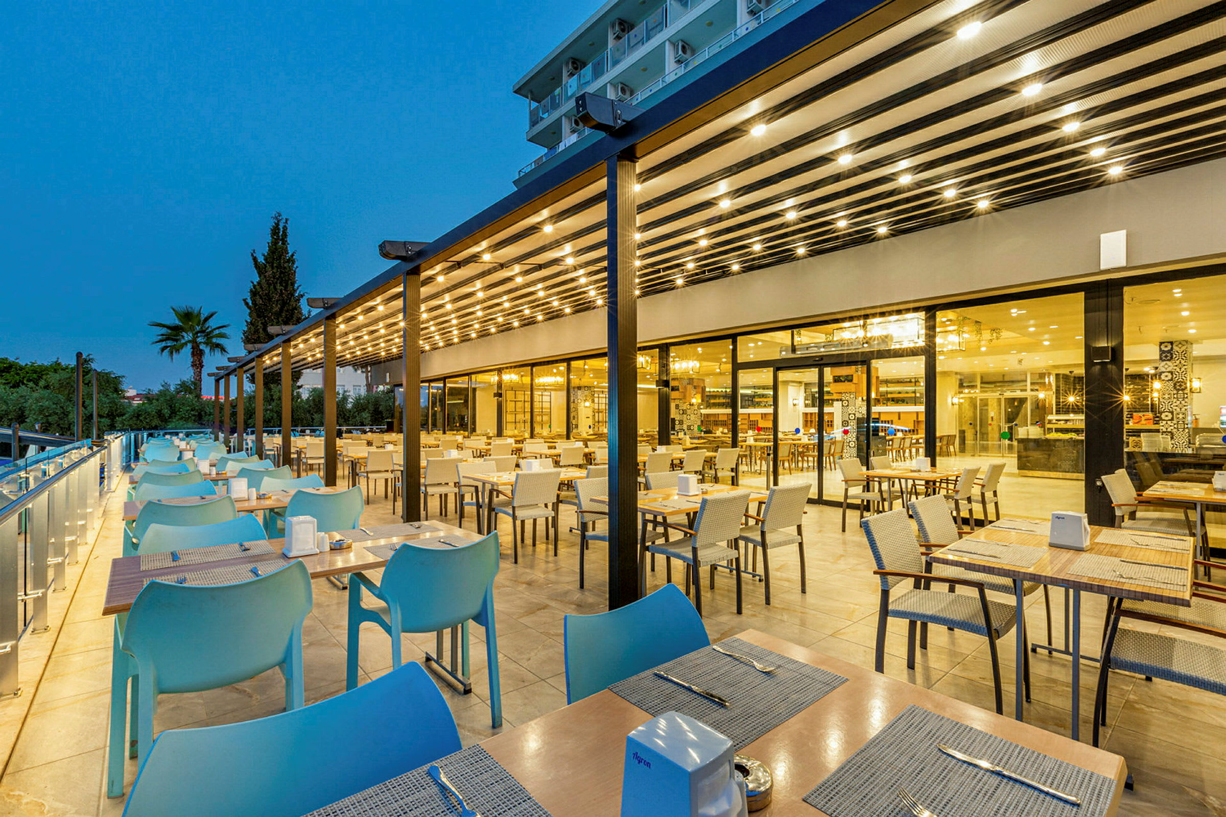 Utomhusserveringen vid en modern restaurang på kvällstid. (AI-genererad text)