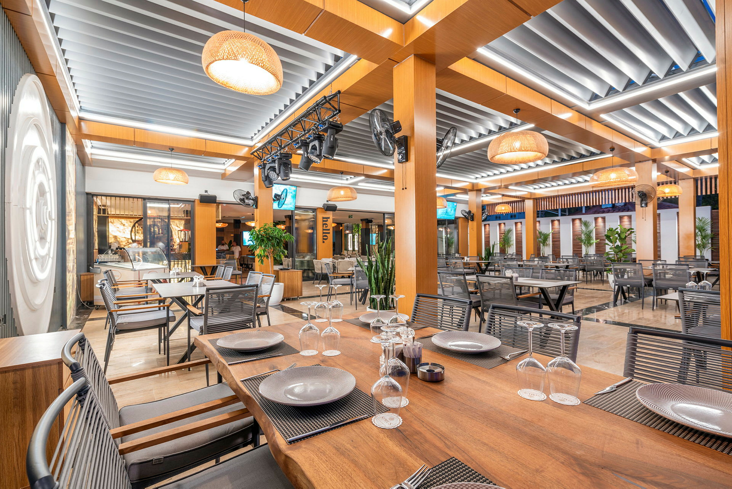 Inomhusmiljö i en modern restaurang med träbord och takdekoration. (AI-genererad text)