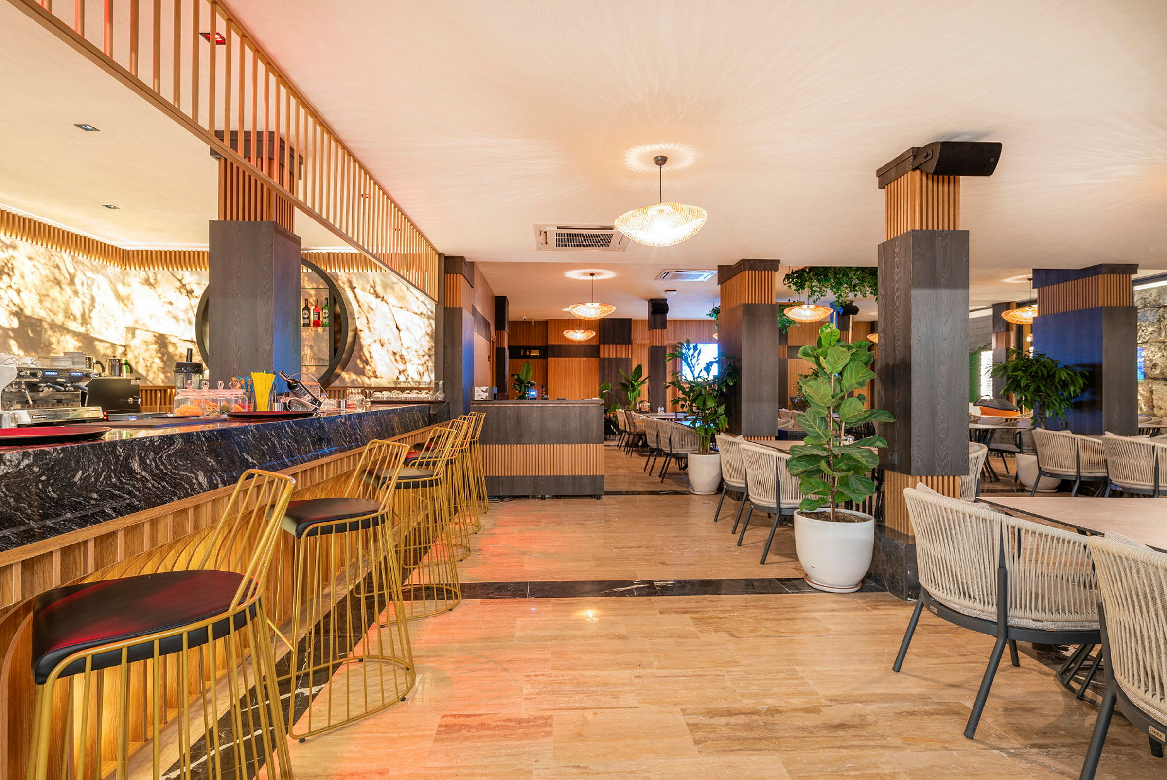 Interiör av en modern bar och lounge med sittplatser och grönska. (AI-genererad text)