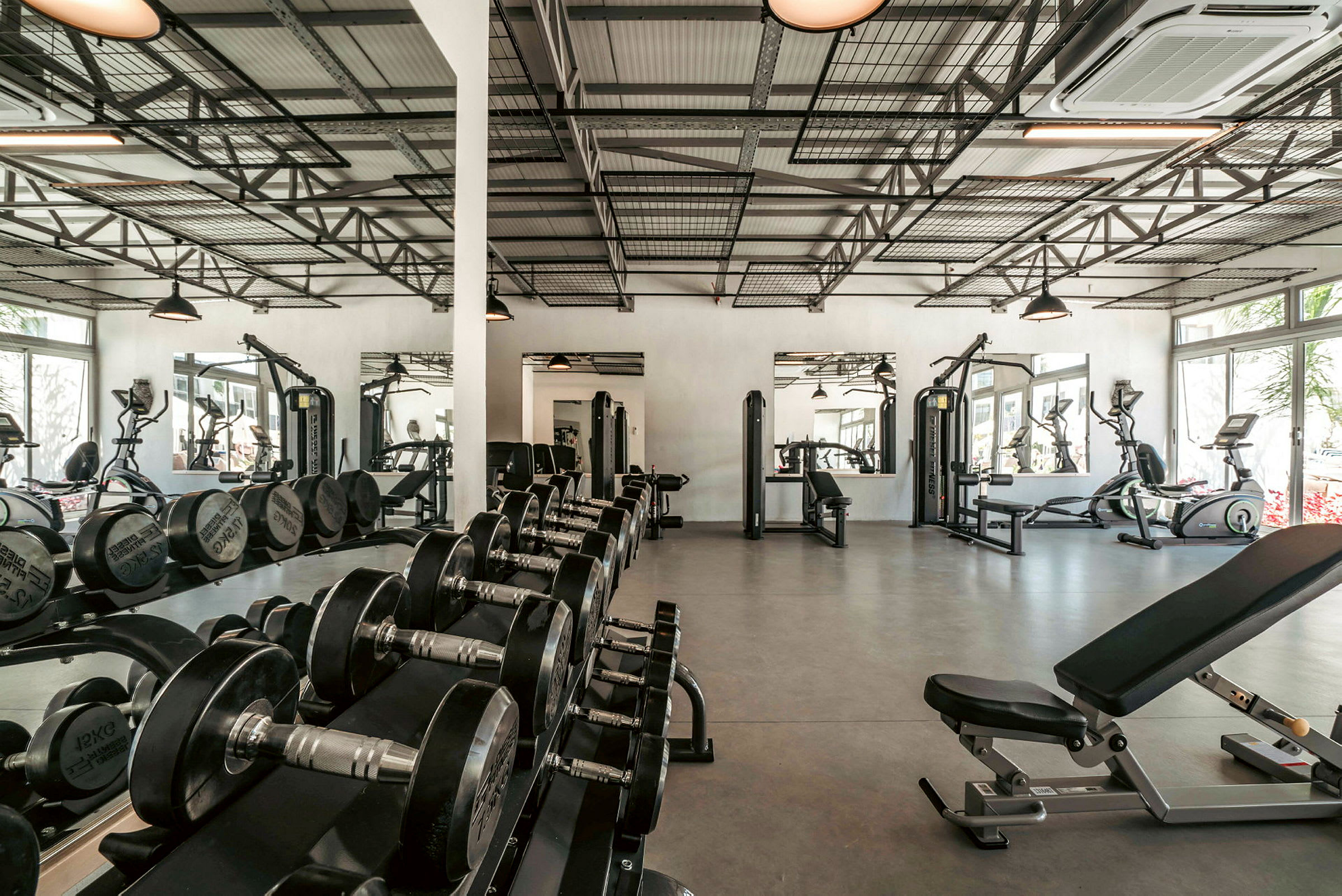 Gym med träningsmaskiner, hantlar och speglar. (AI-genererad text)