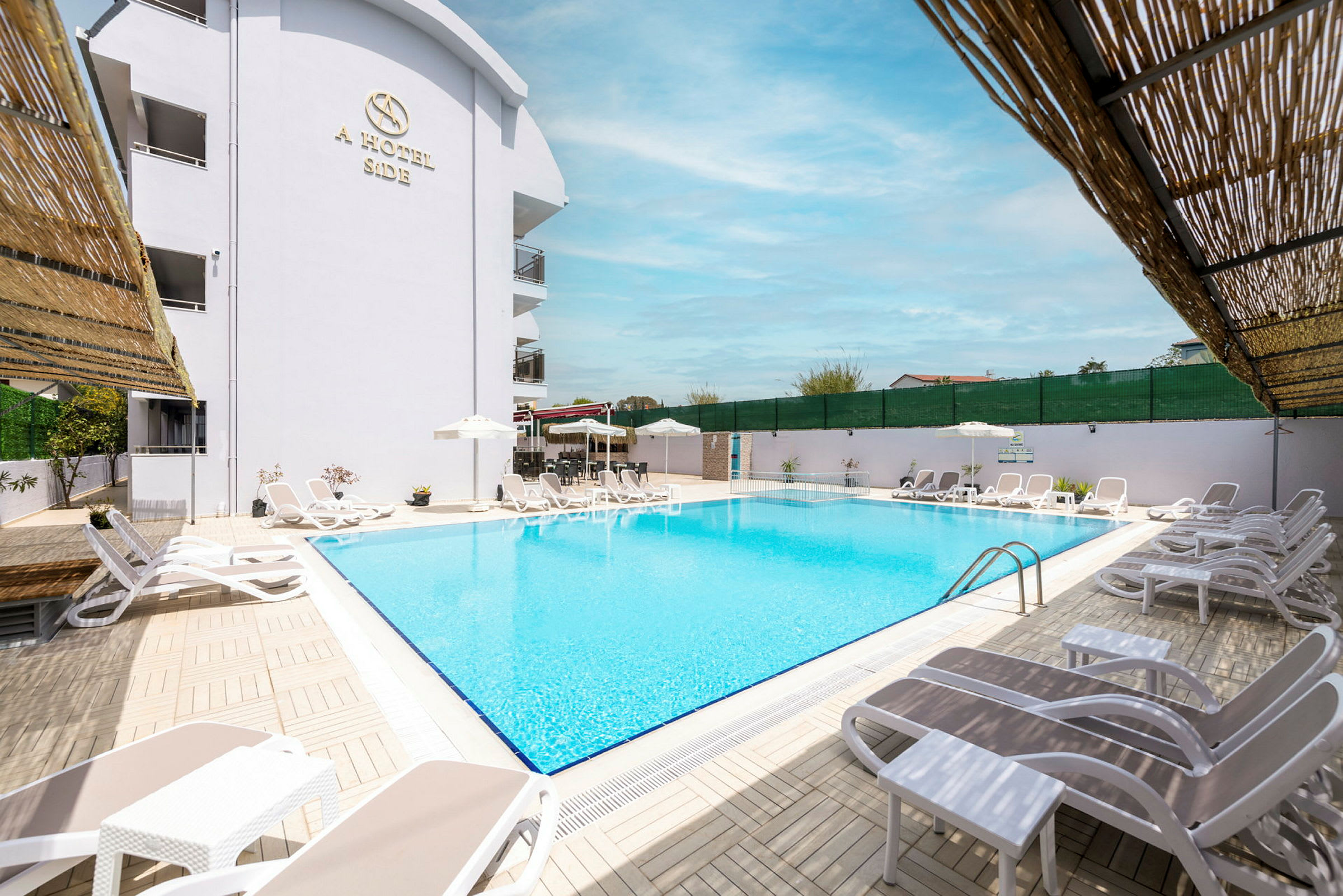 Utomhuspool med solstolar och parasoller vid ett hotell. (AI-genererad text)