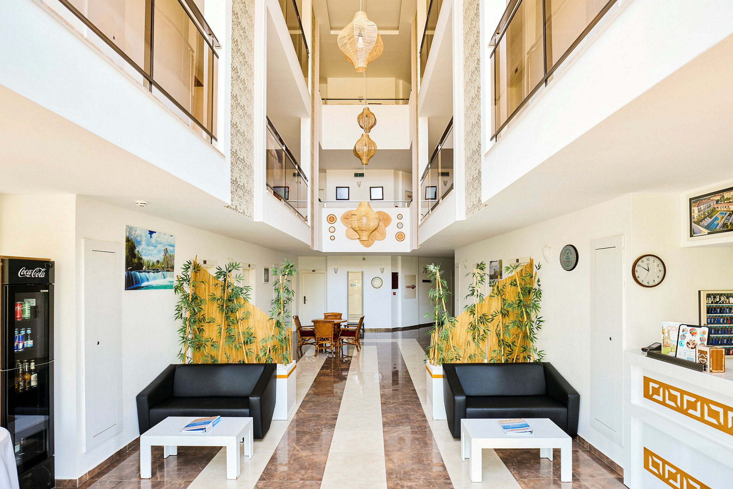 Interiör av en hotelllobby med soffor, bord och dekorationer. (AI-genererad text)