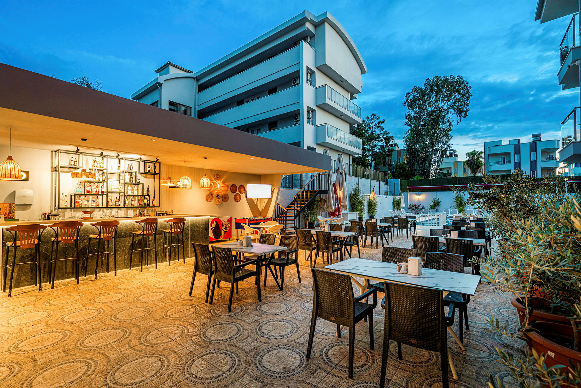 Utomhusrestaurang med bar och sittplatser under kvällstid. (AI-genererad text)
