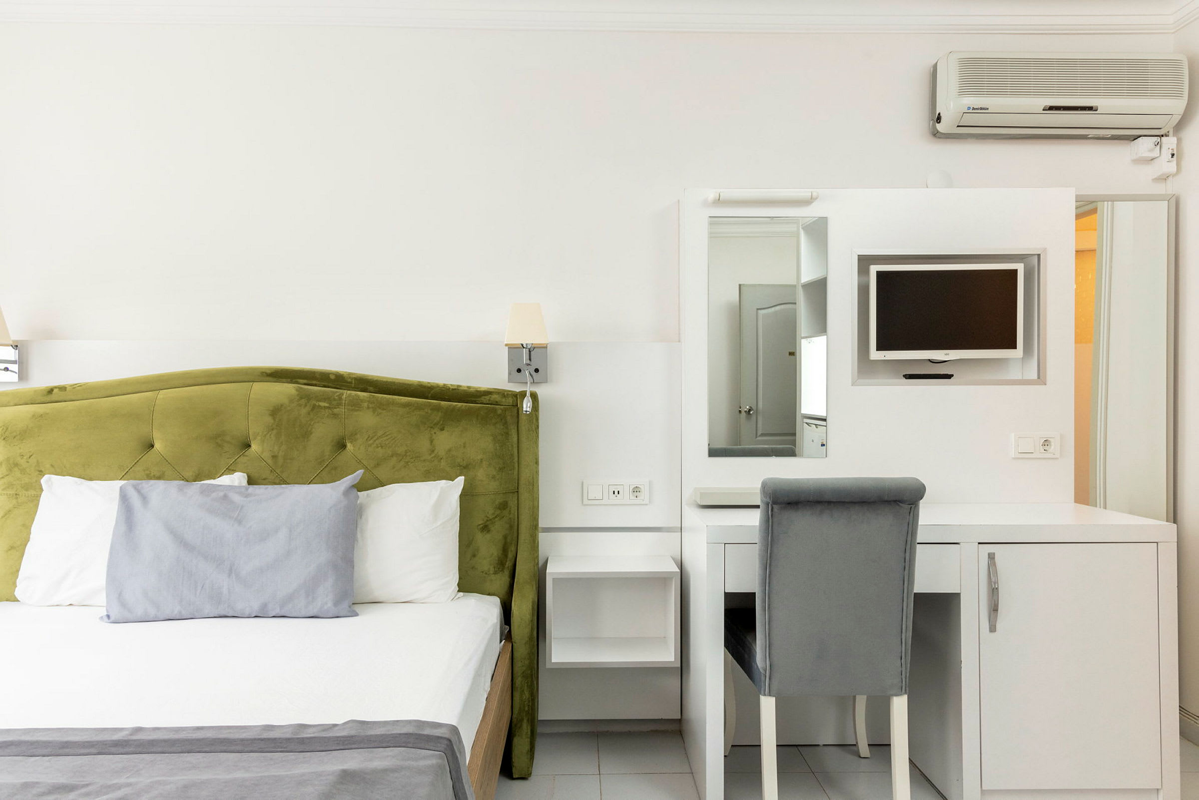 Hotellrum med en säng och skrivbord med stol. (AI-genererad text)