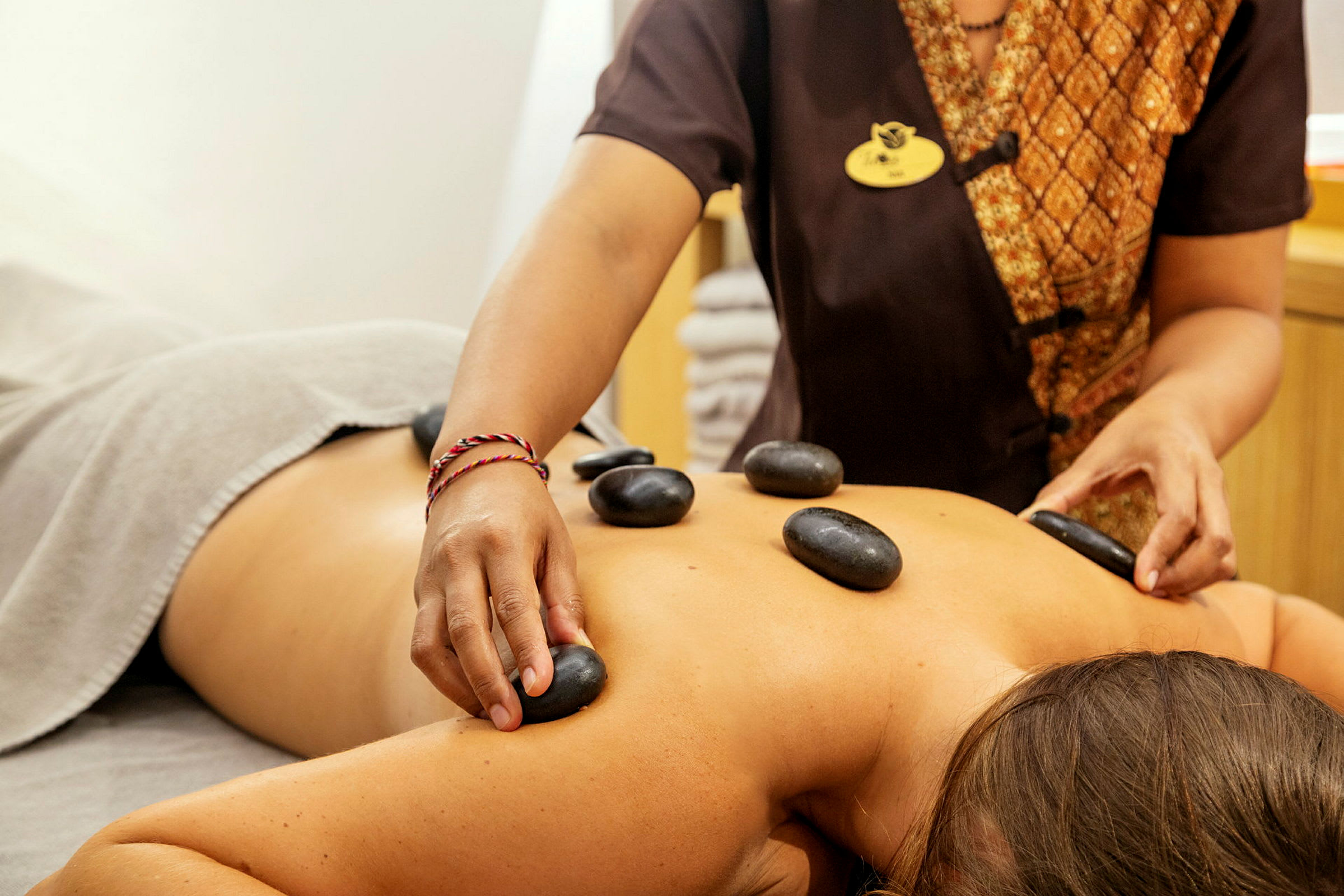 En person får hot stone-massage. (AI-genererad text)