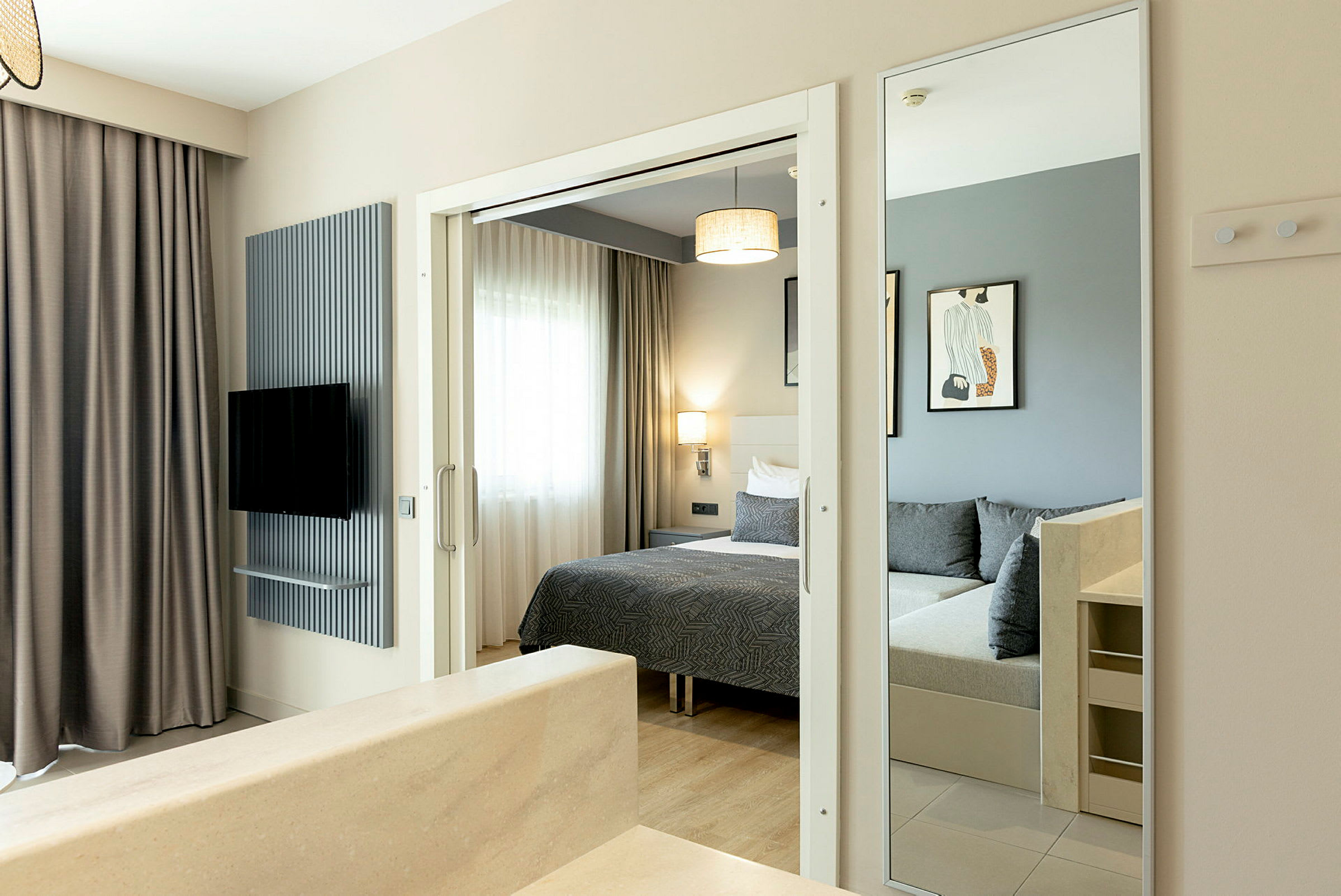 Bild av ett hotellrum med säng, spegel och TV. (AI-genererad text)