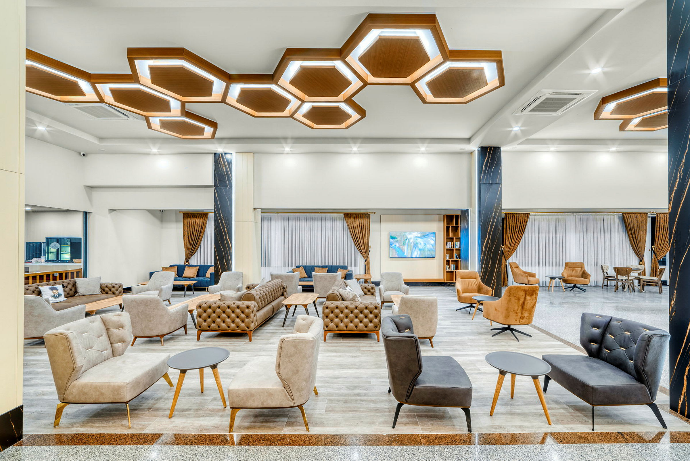Modern hotellobby med eleganta sittmöbler och geometriska taklampor. (AI-genererad text)