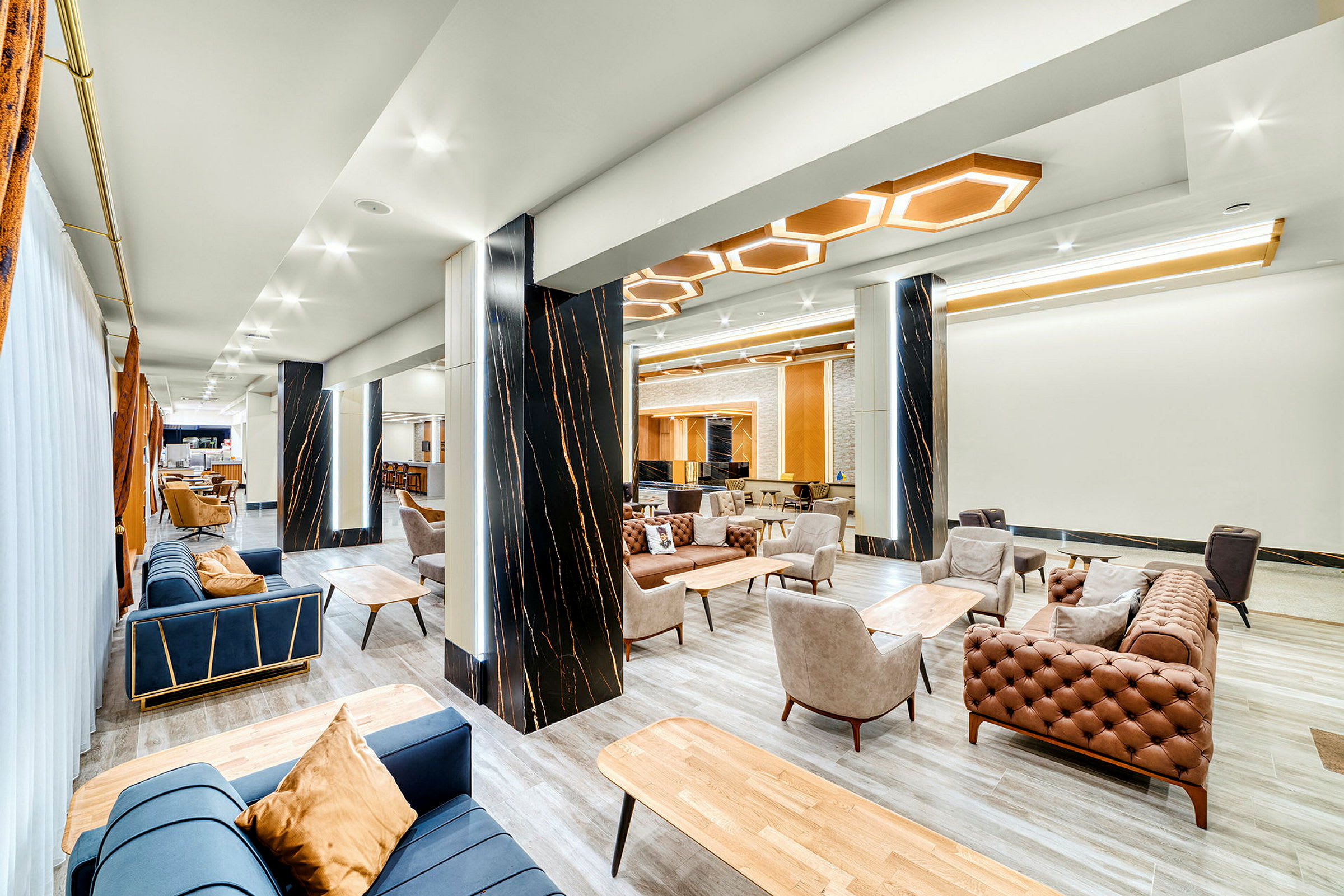 Ett modernt hotellrum med sittmöbler och dekorativa pelare. (AI-genererad text)