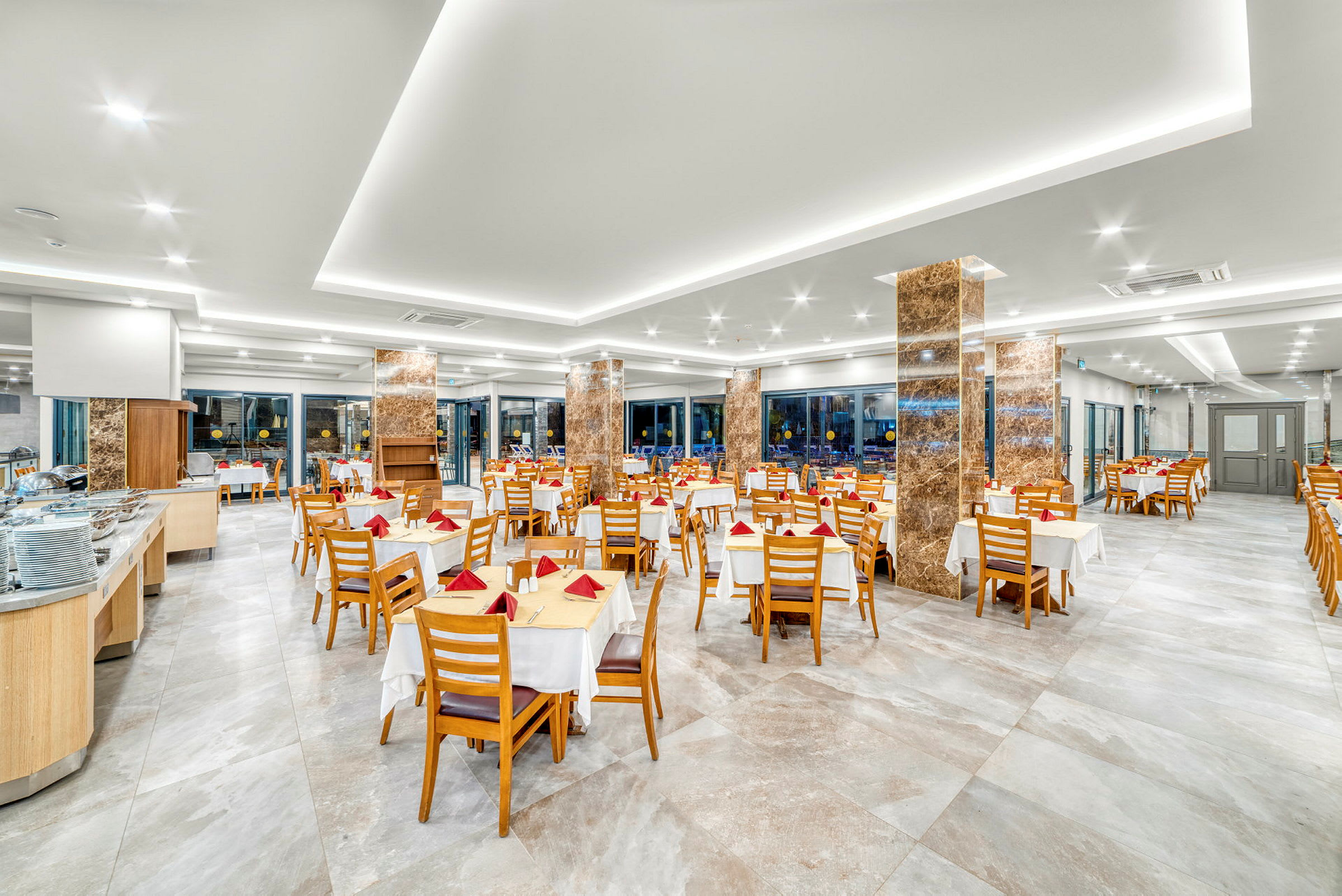 En ljus och rymlig restaurang med dukade bord och trästolar. (AI-genererad text)