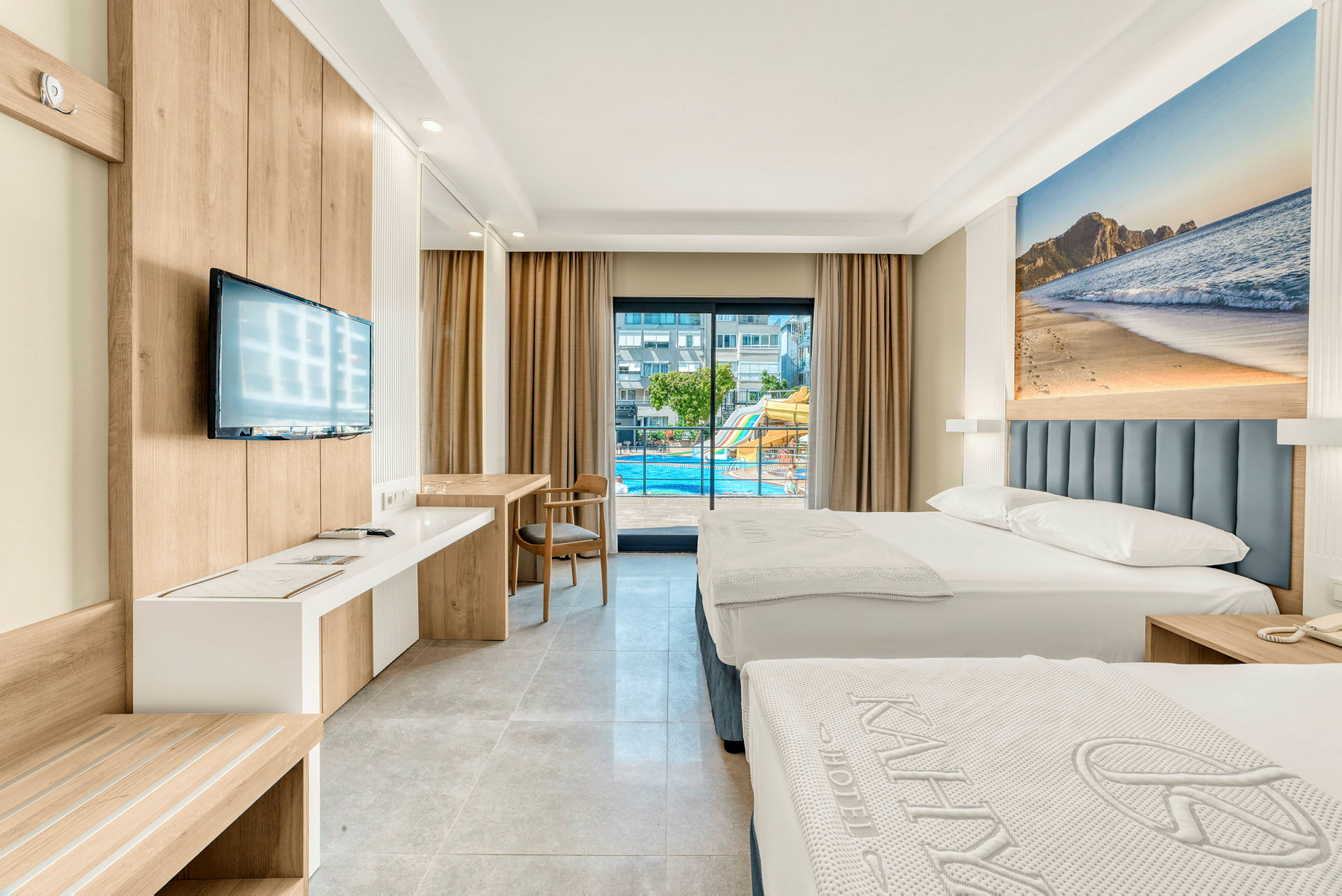 Bild på ett hotellrum med två sängar, en TV på väggen och balkong med utsikt över en pool. (AI-genererad text)