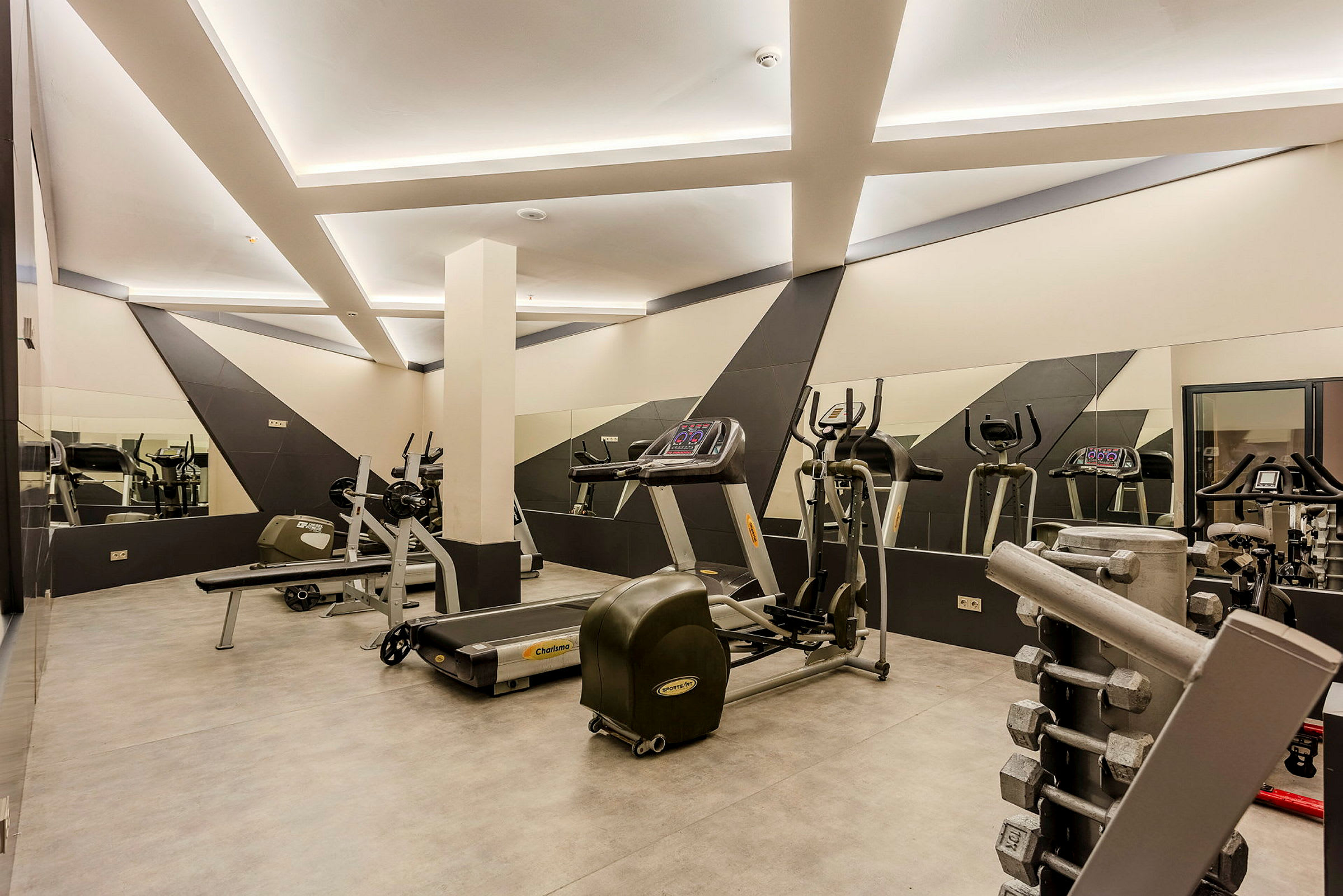 Ett gym med träningsmaskiner och hantlar. (AI-genererad text)
