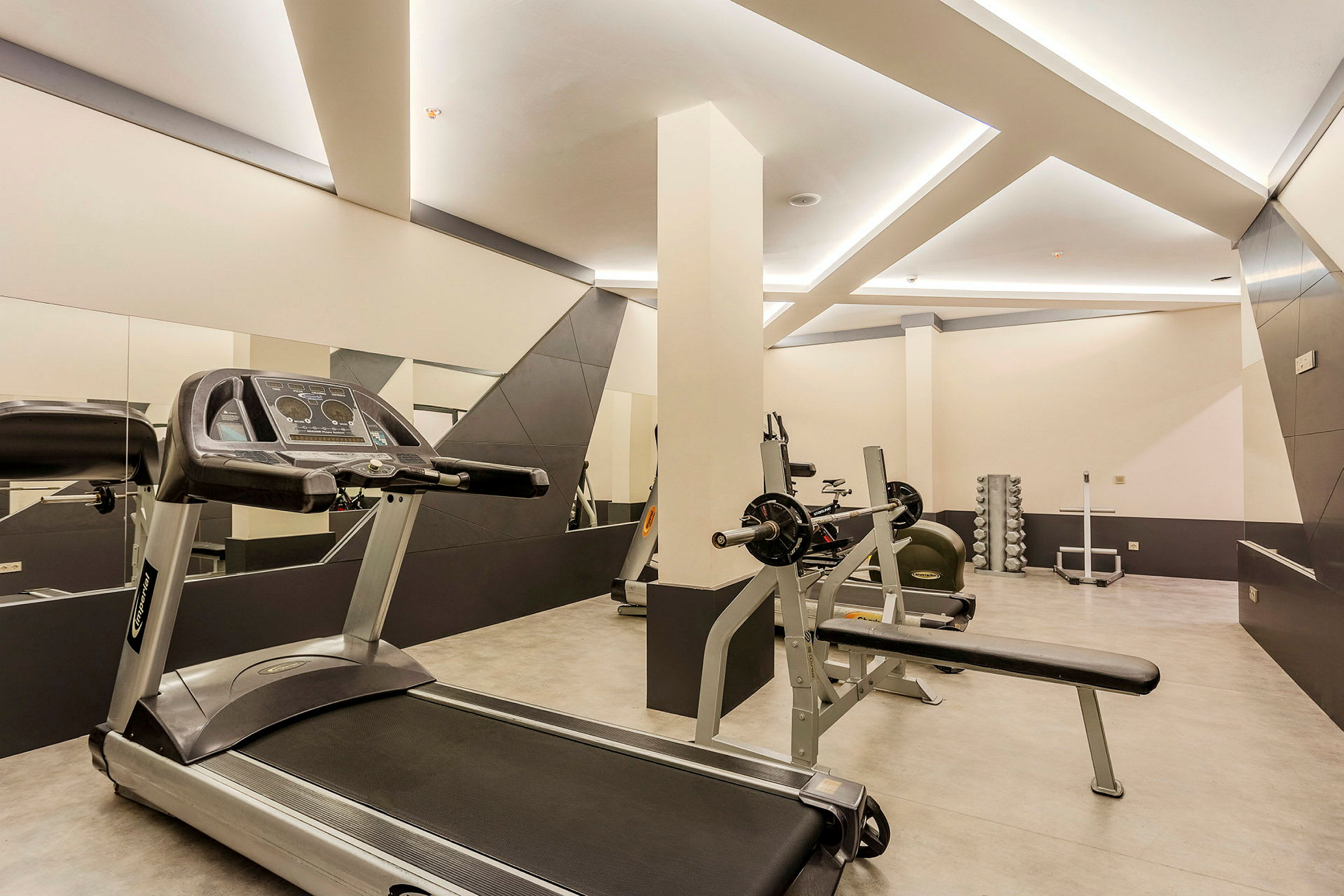 Ett gym med träningsutrustning, inklusive löpband och vikter. (AI-genererad text)