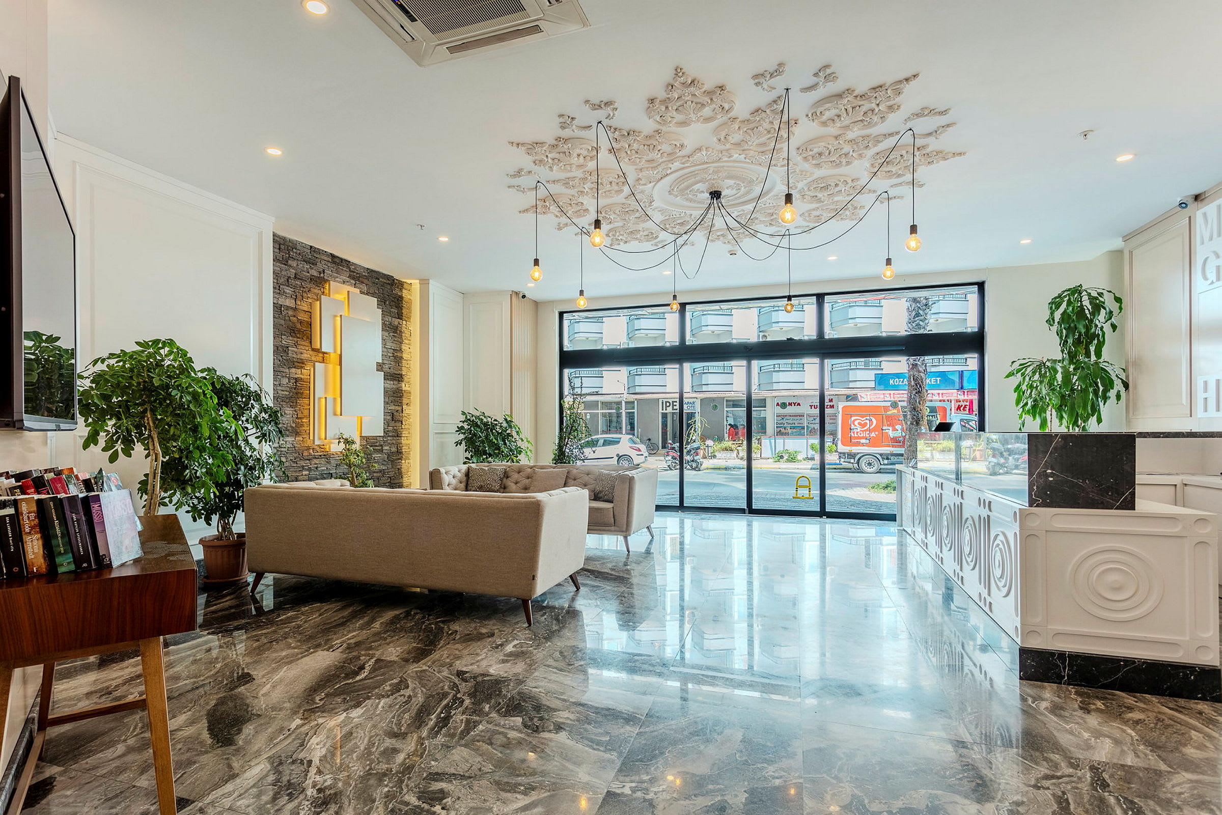Modern hotellobby med soffa, stora fönster och dekorativt tak. (AI-genererad text)