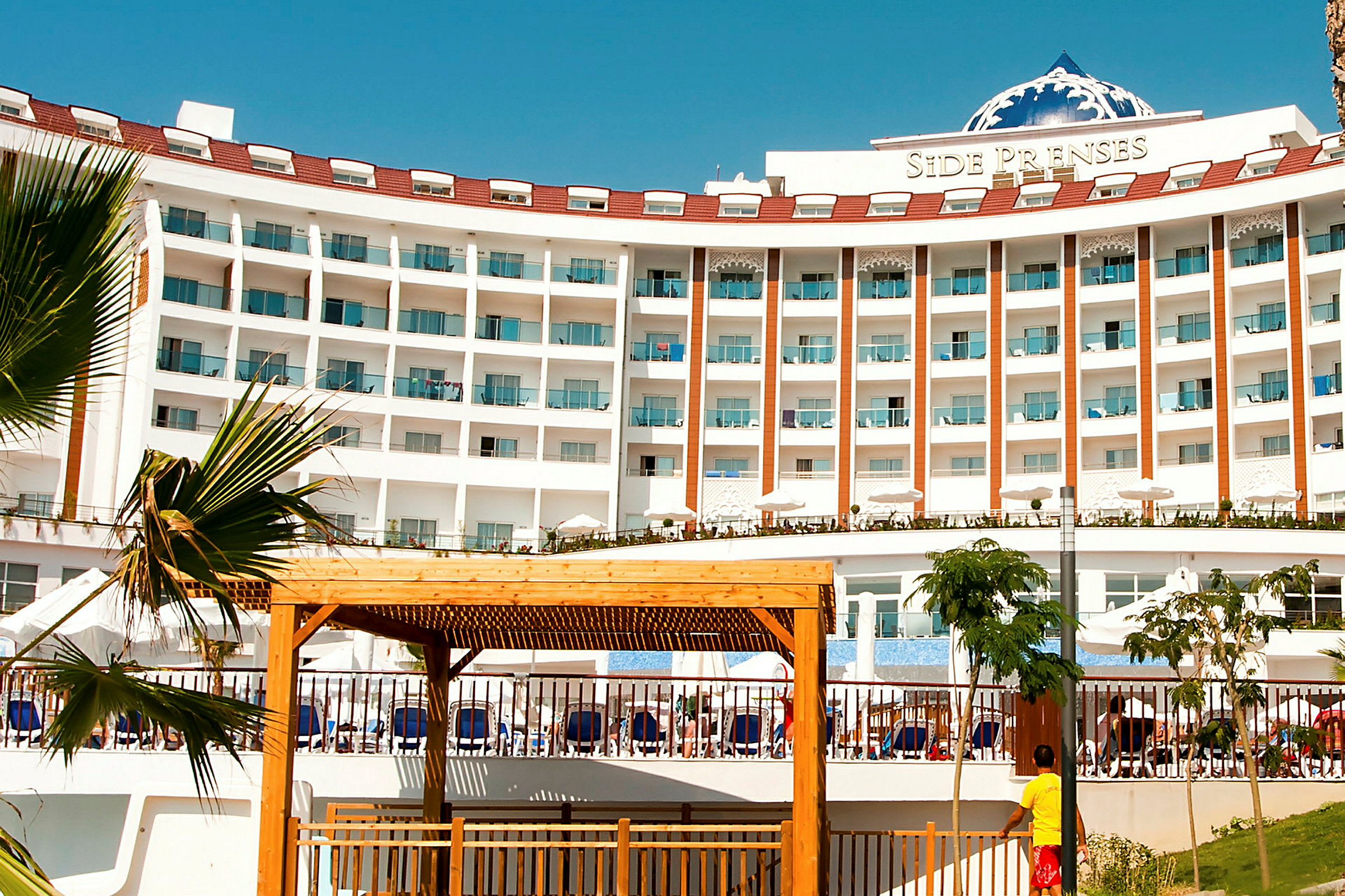 Hotellkomplex med balkonger och en utomhuspool. (AI-genererad text)