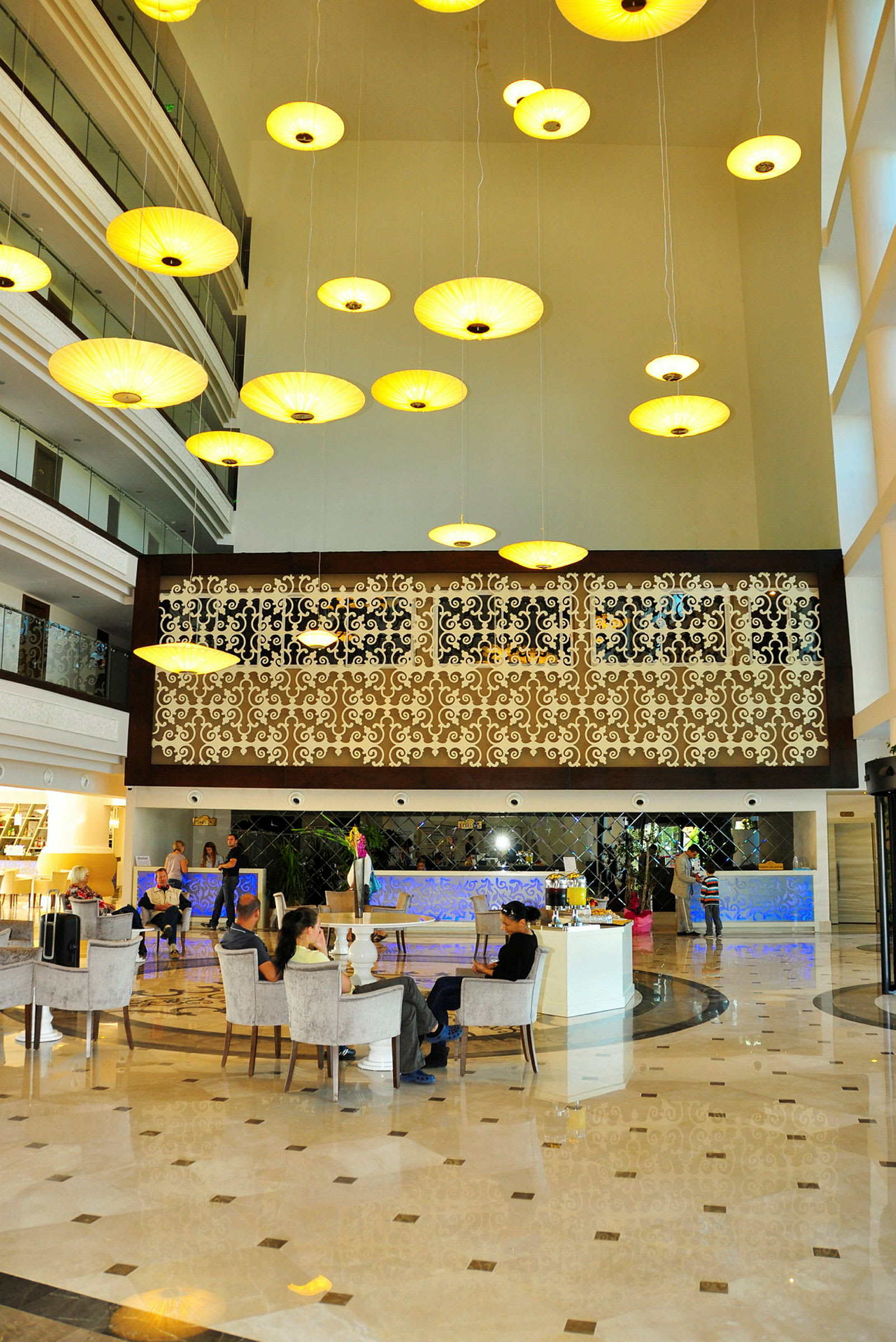 Hotellets lobby med eleganta hängande lampor och sittplatser. (AI-genererad text)