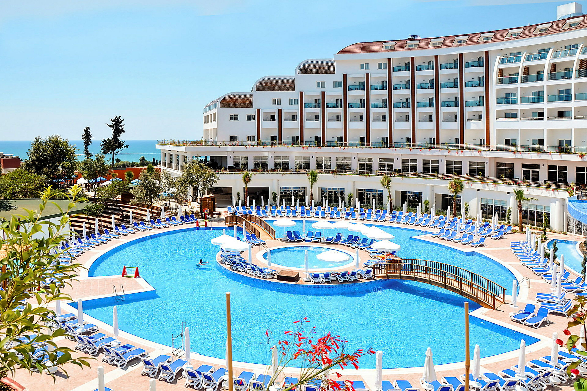 Hotell med stor pool och solstolar vid havet. (AI-genererad text)