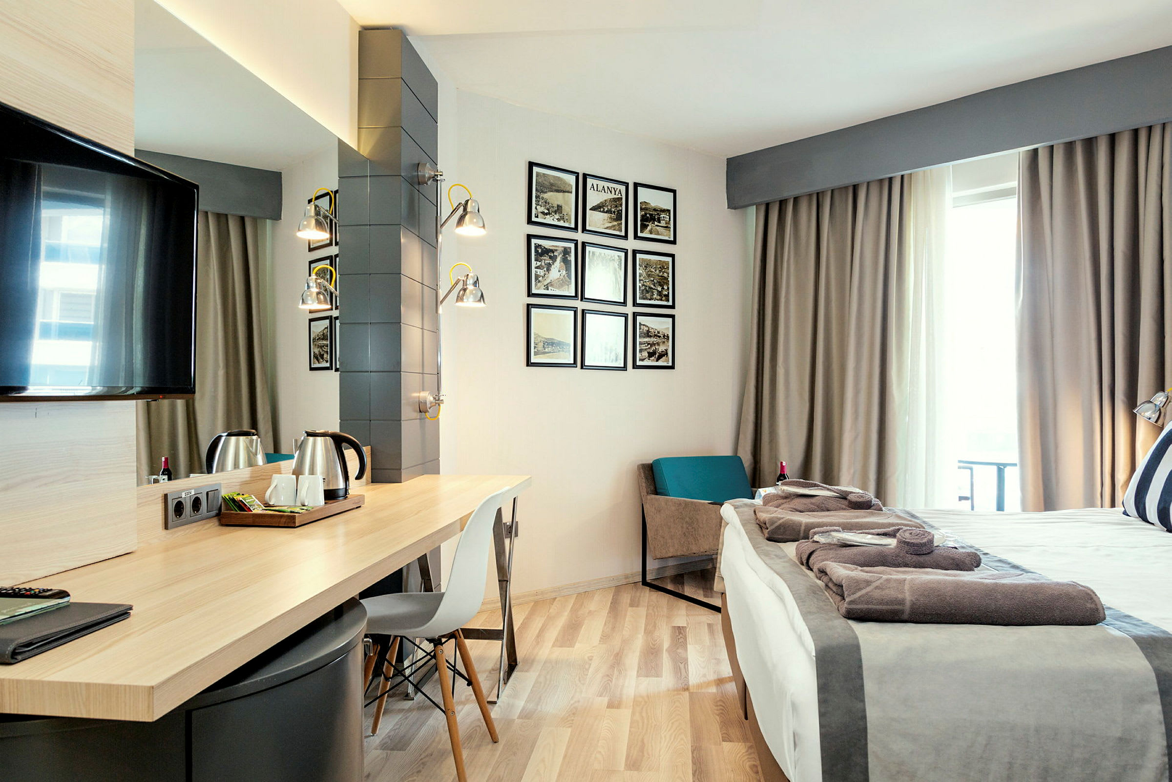 Hotellrum med skrivbord, säng och dekorationer på väggen. (AI-genererad text)