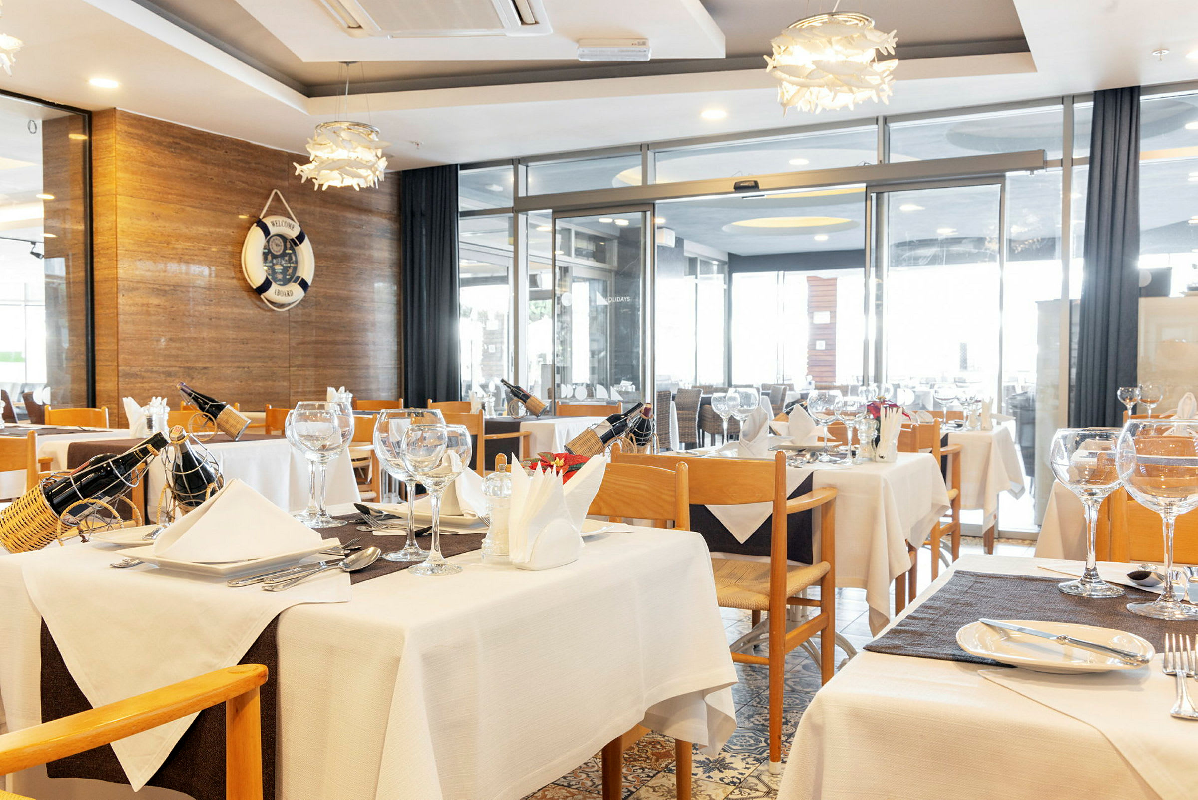 En restaurang med dukade bord och trästolar. (AI-genererad text)