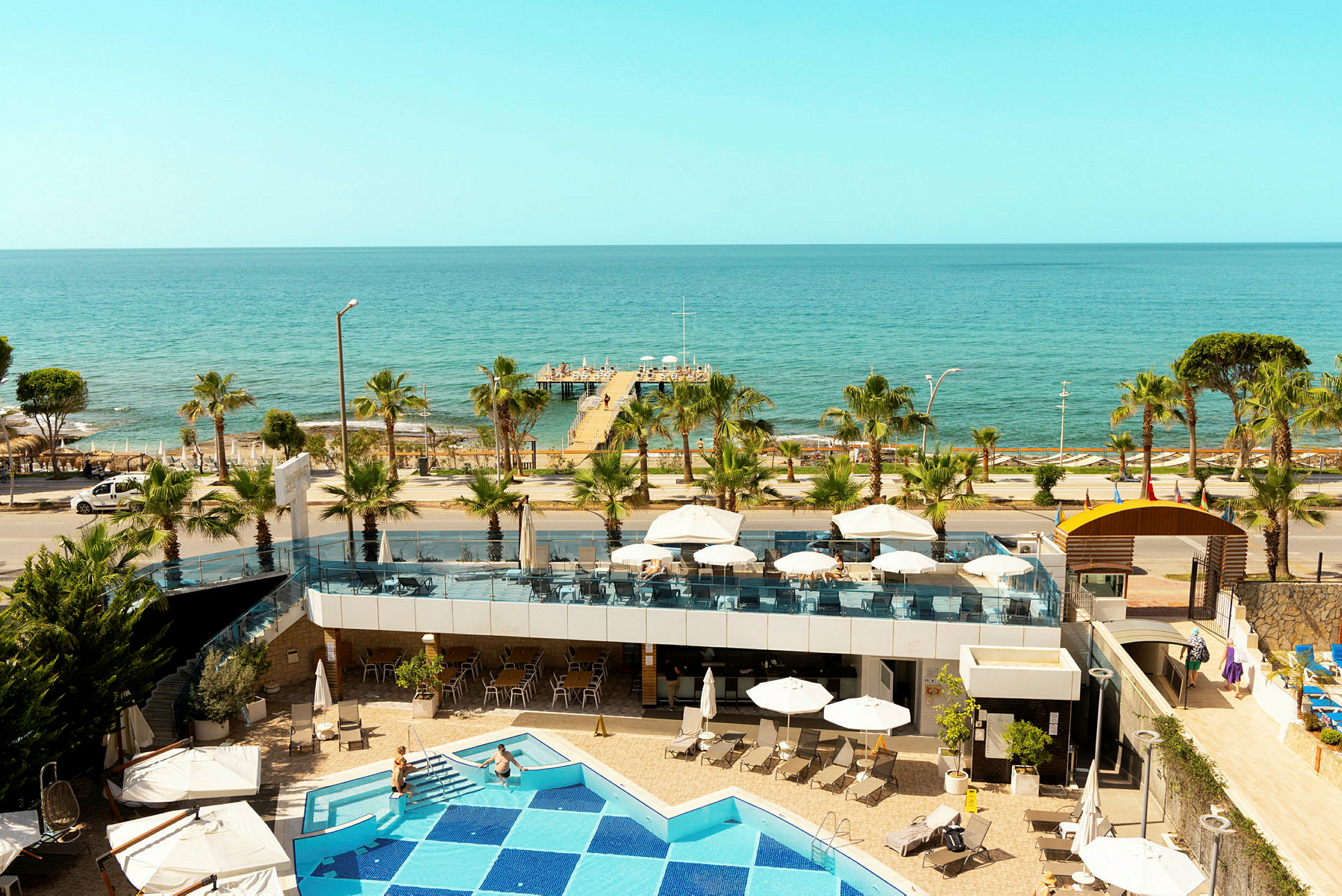Utsikt från hotellet mot havet med pool, terrass och brygga. (AI-genererad text)