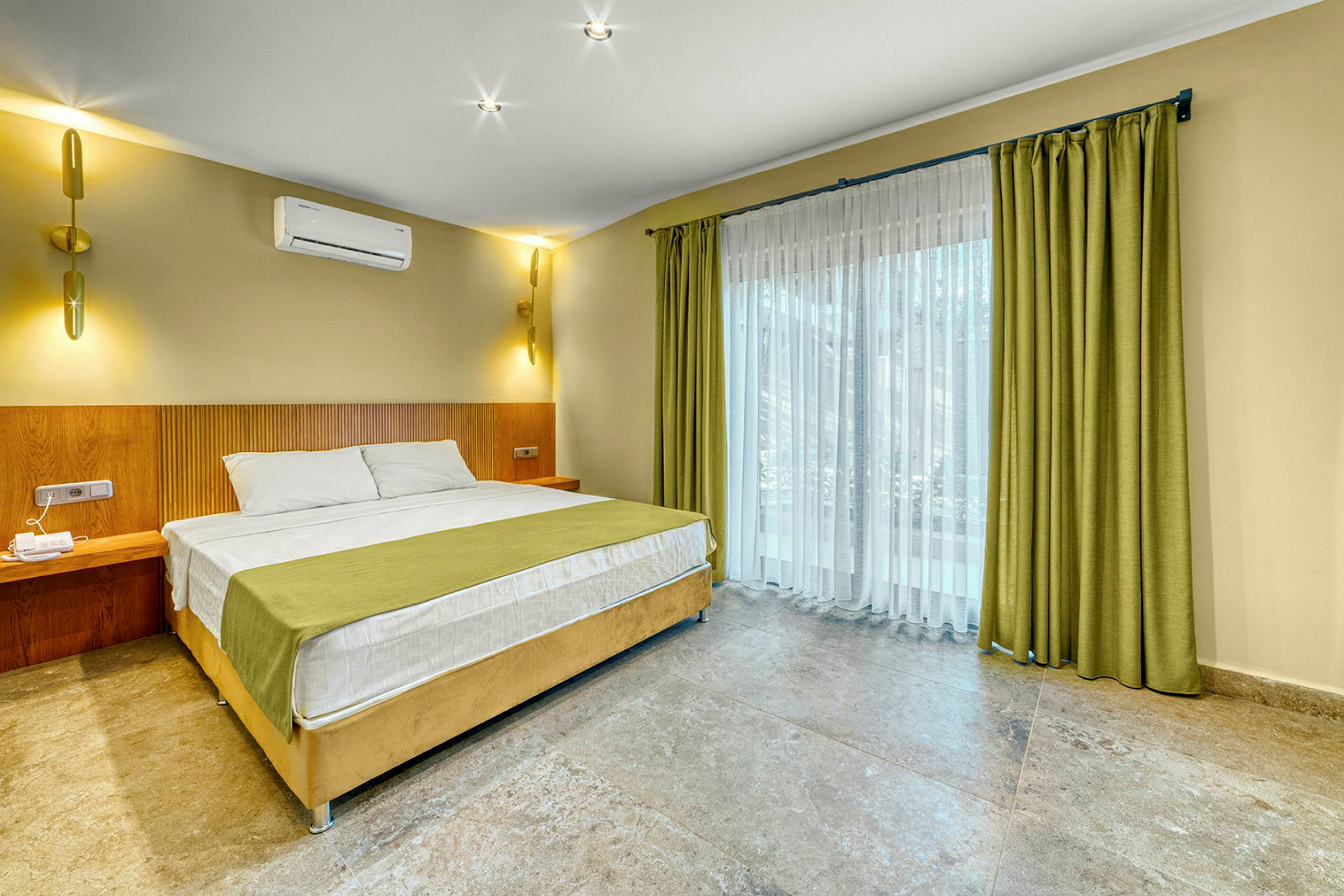 Modernt hotellrum med en stor säng, gröna gardiner och ljusa väggar. (AI-genererad text)