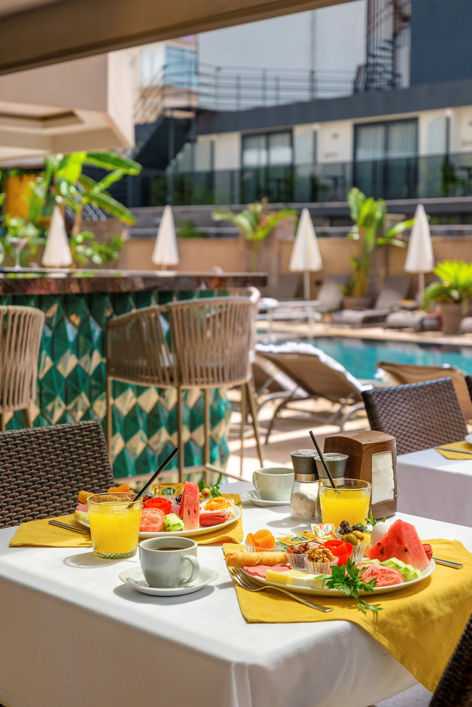 En uppdukad hotellfrukost vid poolområdet. (AI-genererad text)