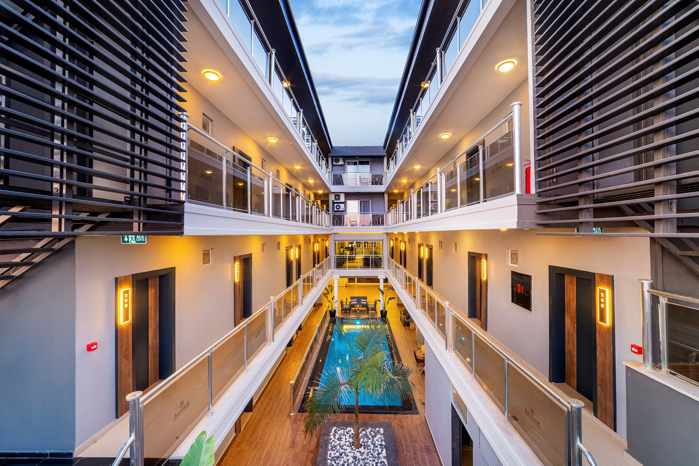 Interiören visar en modern byggnad med pool och balkonger. (AI-genererad text)