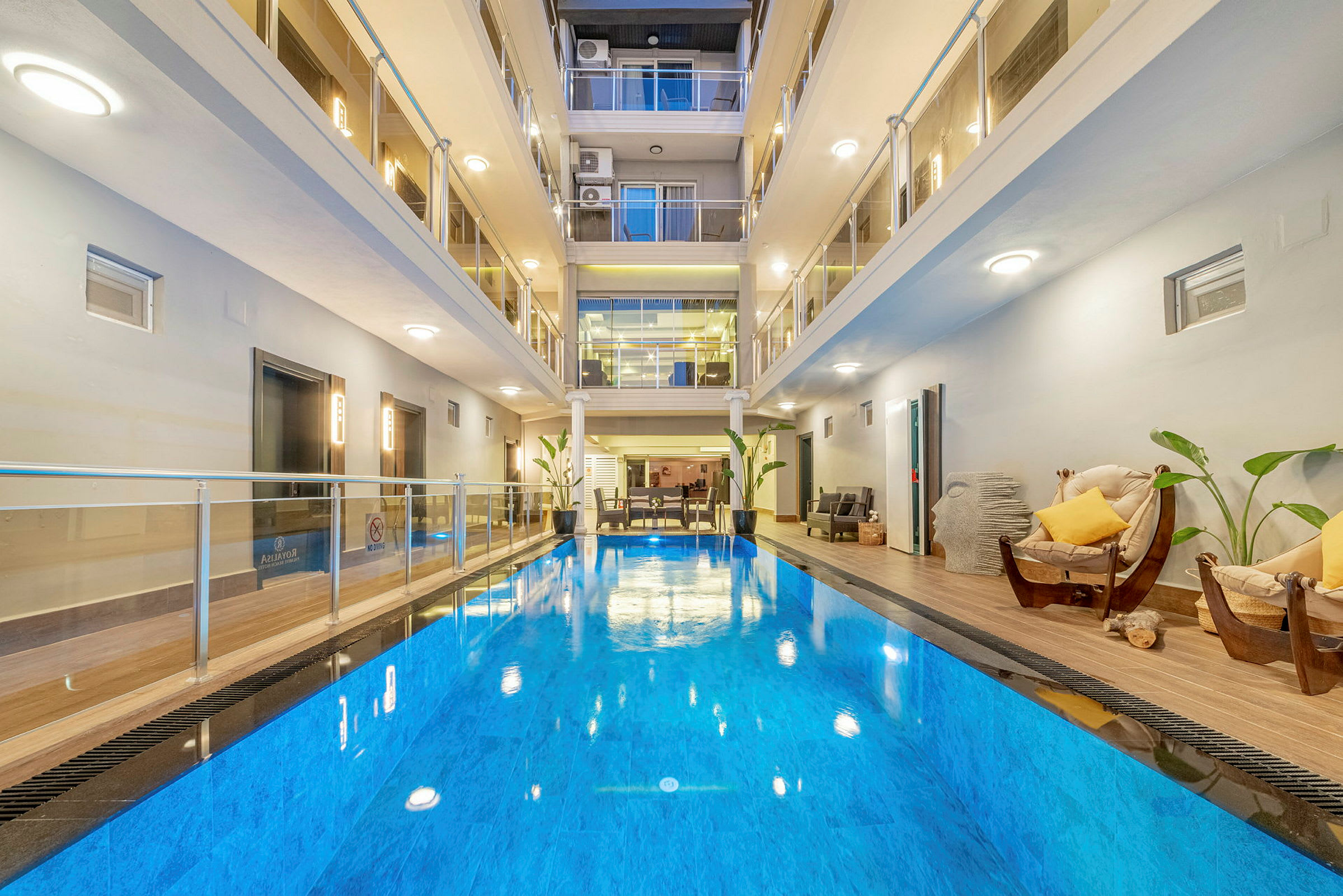 Inomhuspool i ett modernt hotell med omgivande sittplatser. (AI-genererad text)