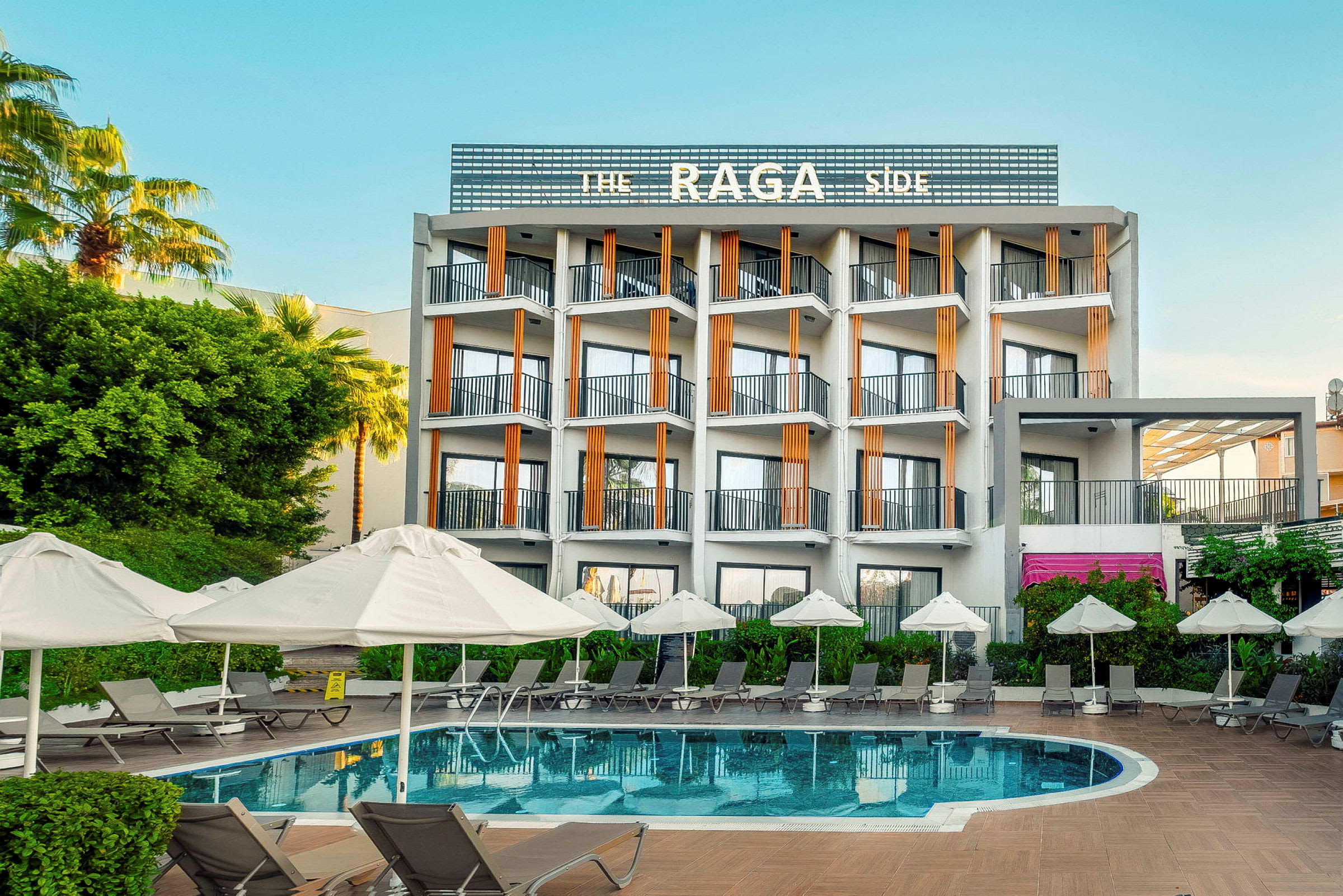 Ett hotell med en utomhuspool och solstolar med parasoller. (AI-genererad text)