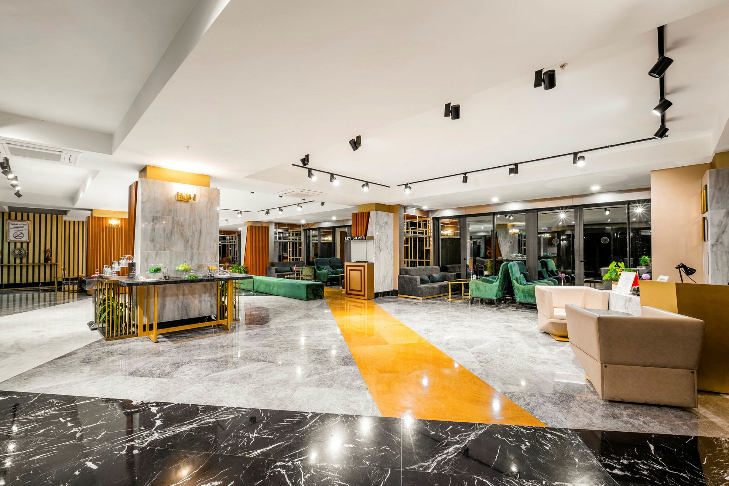 Ett elegant hotelllobby med modern inredning, marmorgolv och bekväma sittgrupper. (AI-genererad text)