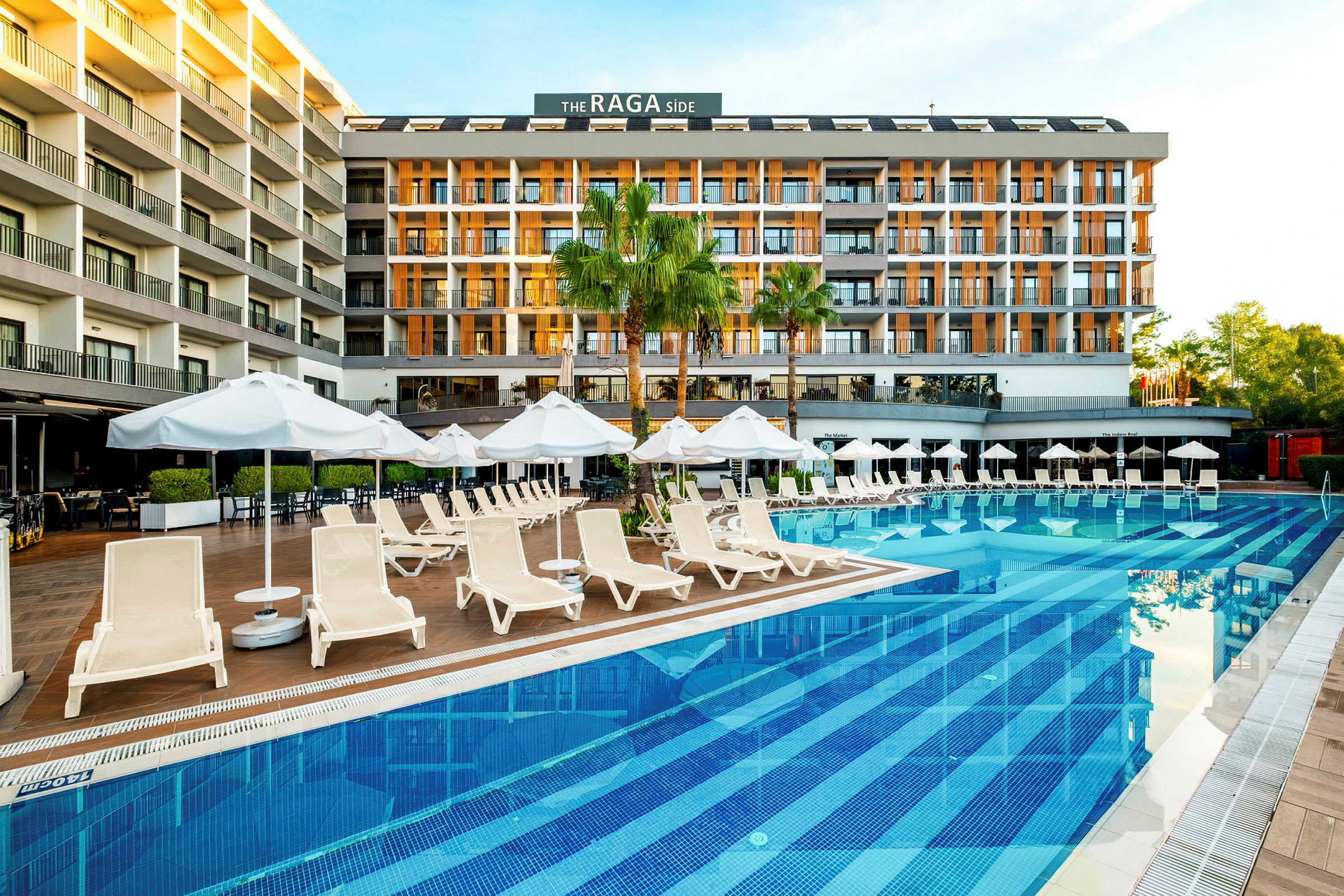 Ett hotell vid en pool med solstolar och parasoller. (AI-genererad text)
