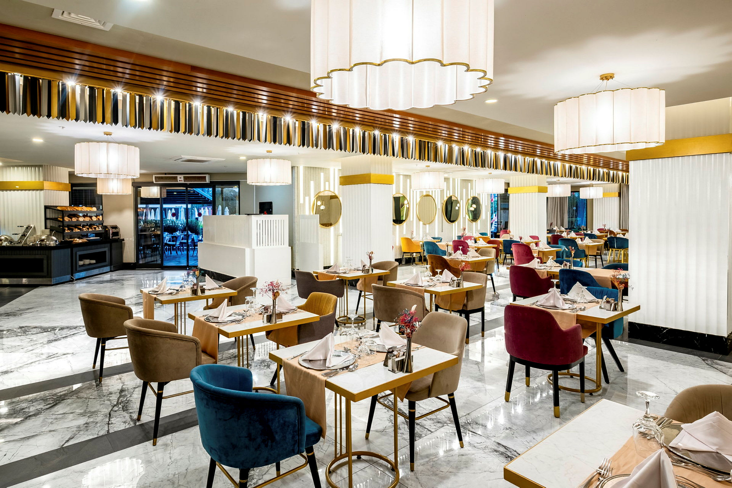 En ljus och elegant restaurang med marmorgolv, dukade bord och färgglada stolar. (AI-genererad text)
