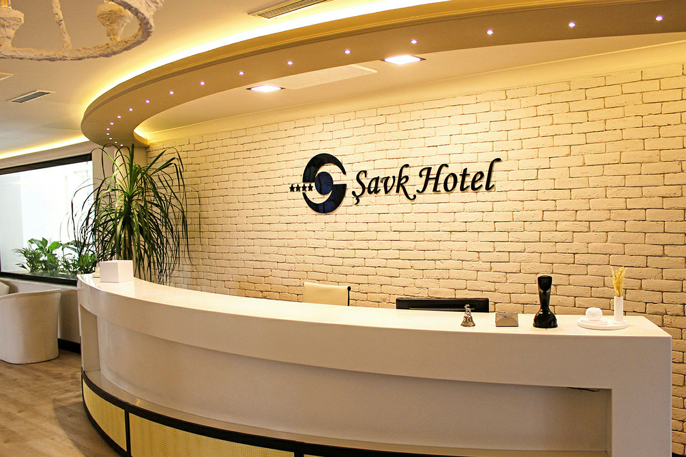 Receptionen i ett hotell med en vit disk och tegelvägg. (AI-genererad text)