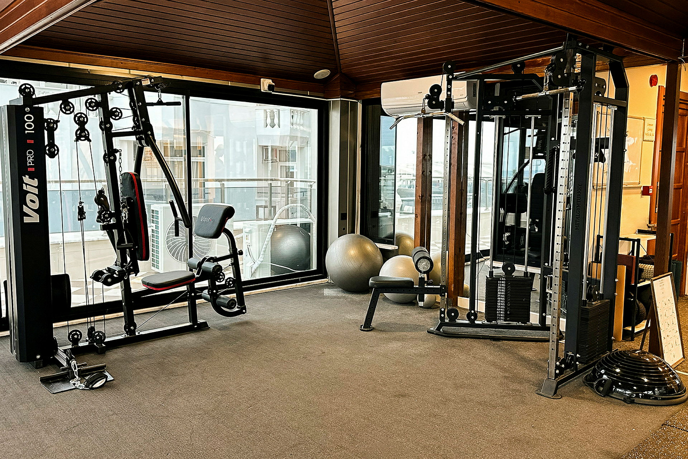 Gym utan människor, träningsutrustning som maskiner och bollar. (AI-genererad text)