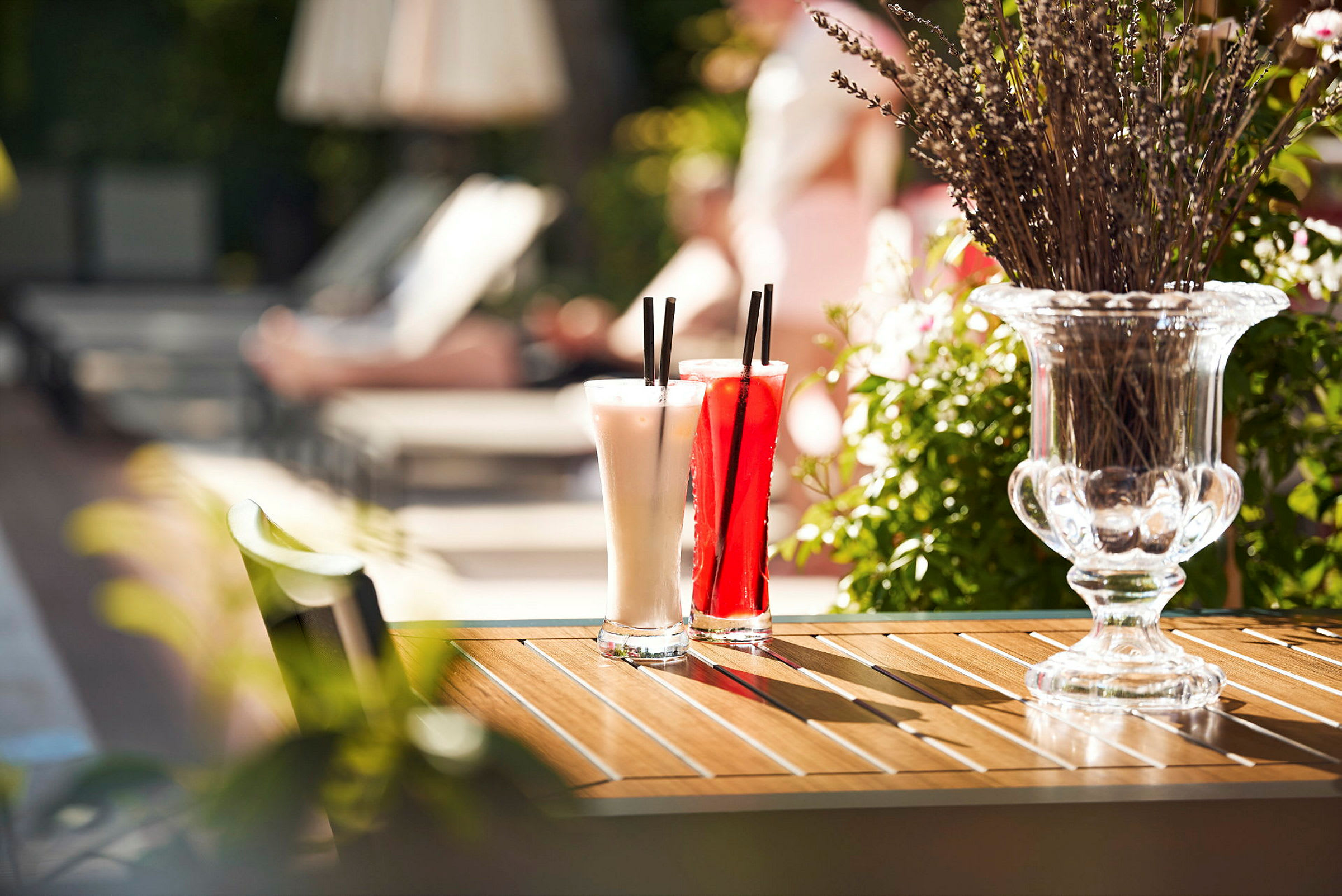 Två cocktailglas står på ett bord bredvid en vas med lavendel. (AI-genererad text)