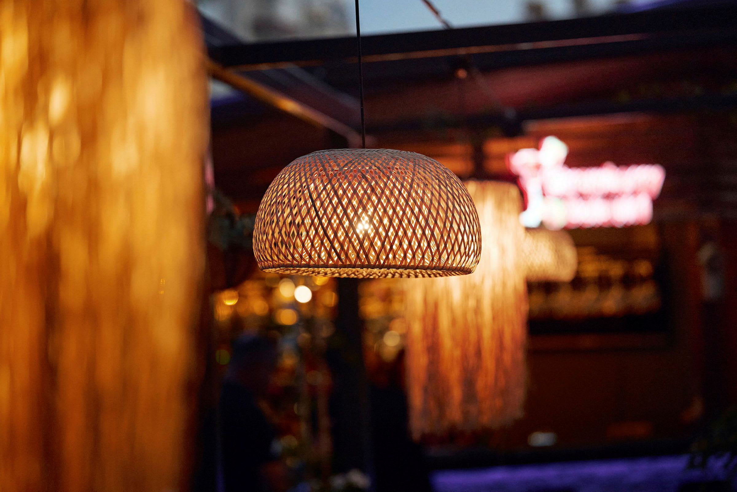 Flätad lampskärm med varmt ljus på en restaurang. (AI-genererad text)