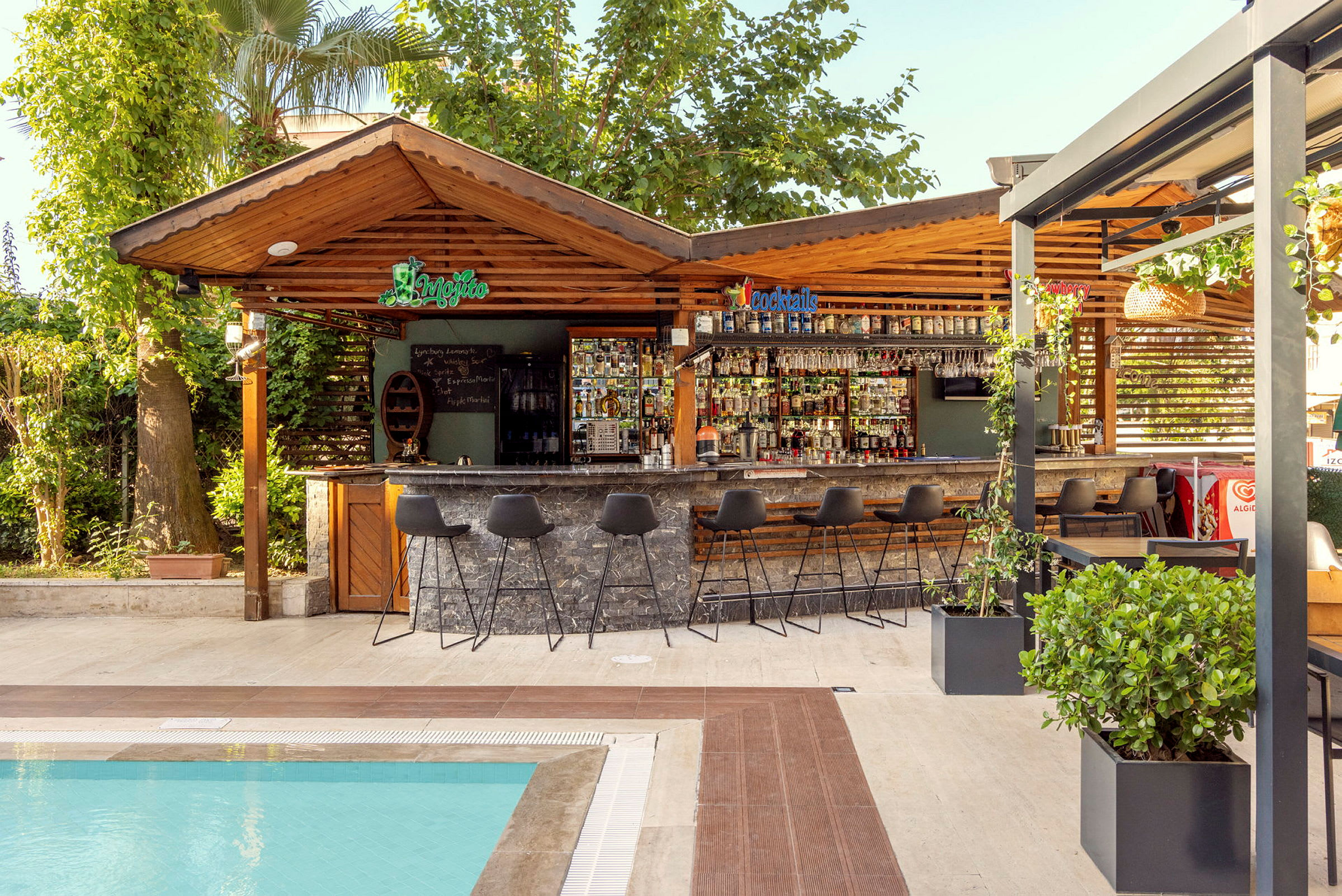 En uteservering vid en pool, med en bar och stolar. (AI-genererad text)