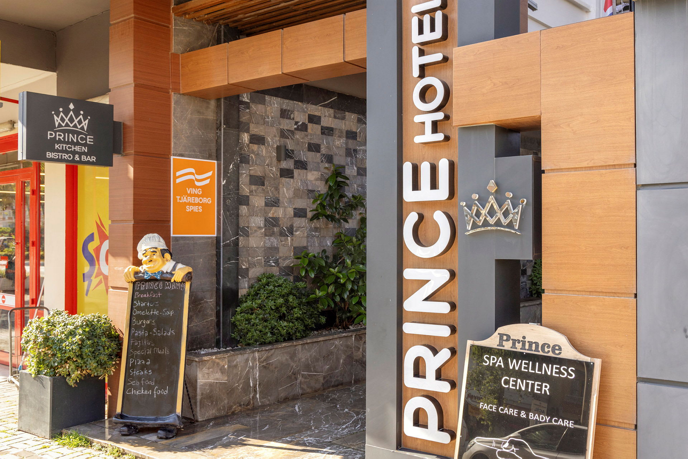 Entré till Prince Hotel med skyltar för restaurang och wellness-center. (AI-genererad text)