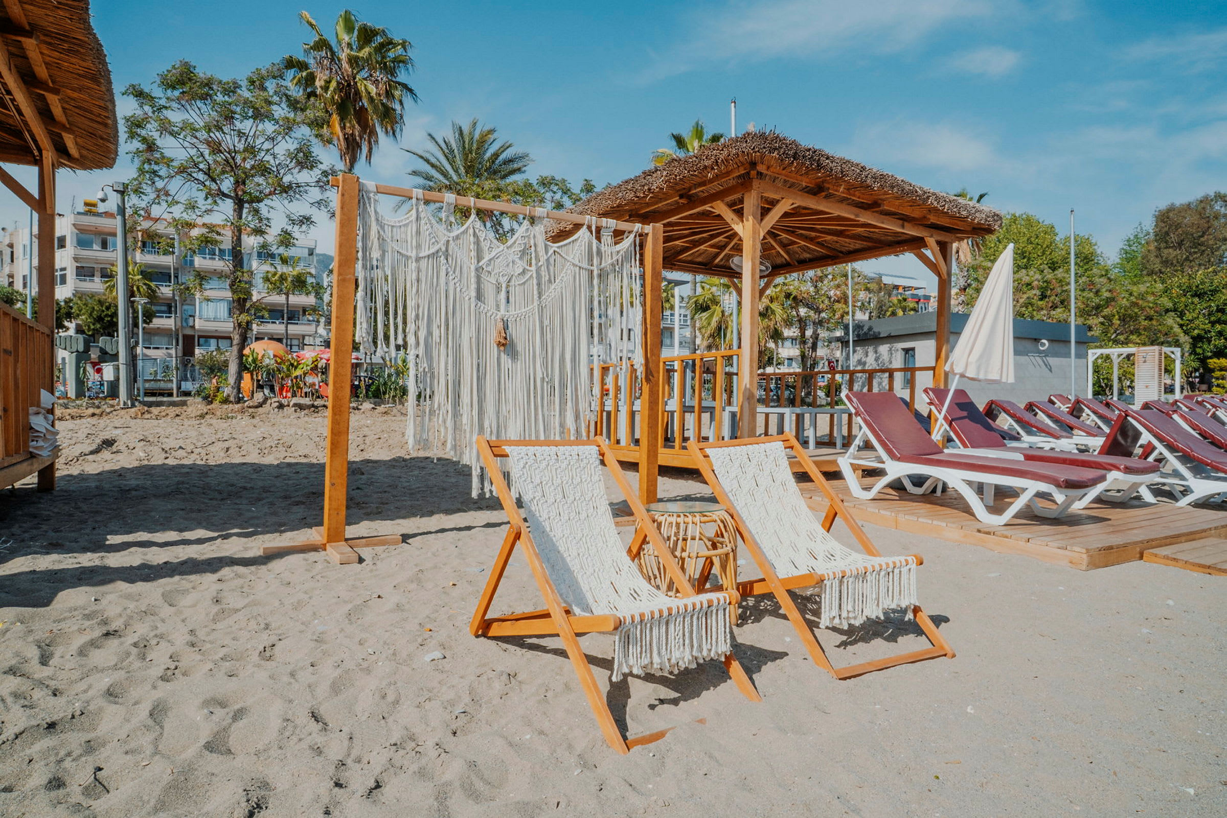Två solstolar och en hydda vid en strand. (AI-genererad text)