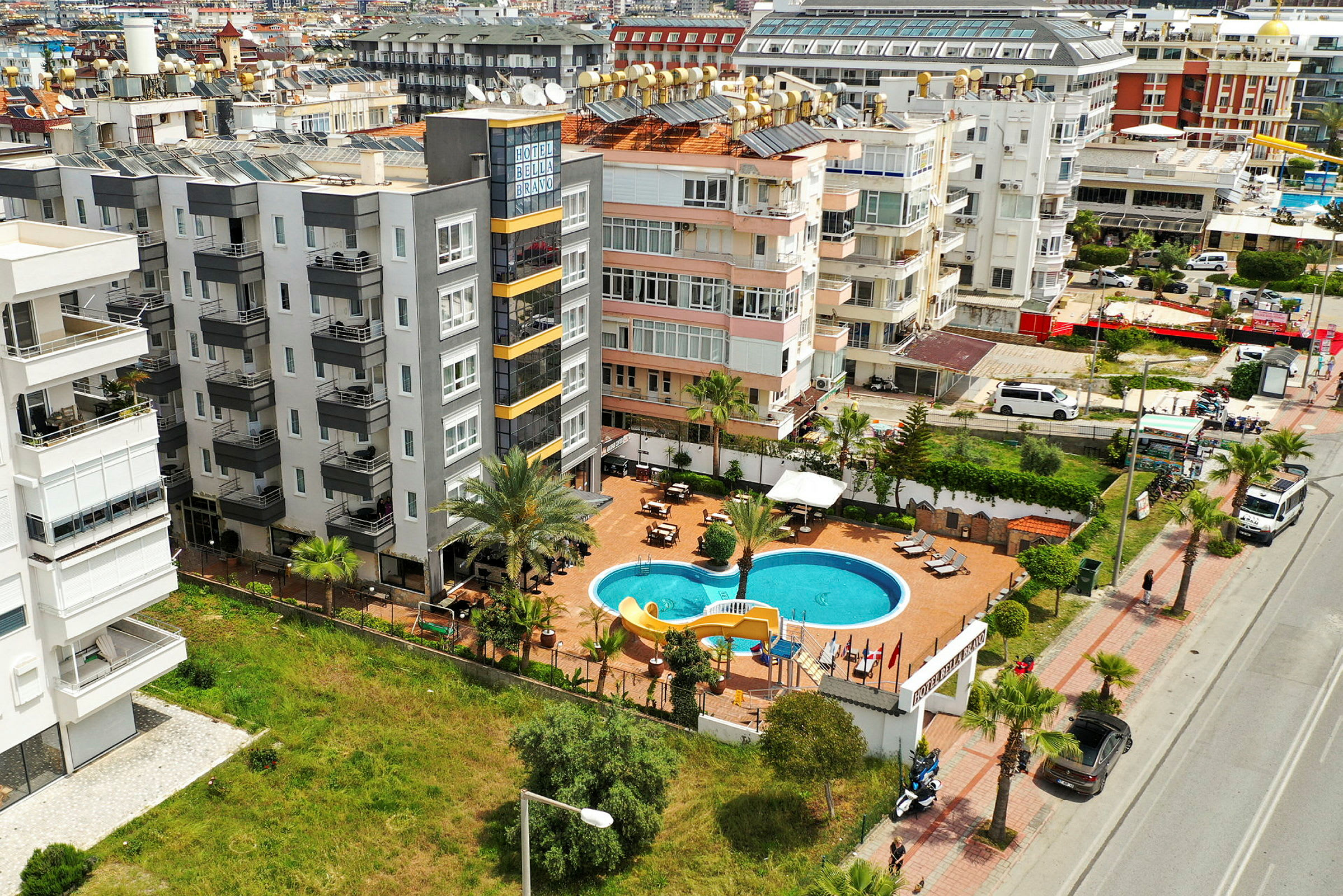 En flygbild visar ett hotellområde med en pool och omgivande byggnader. (AI-genererad text)