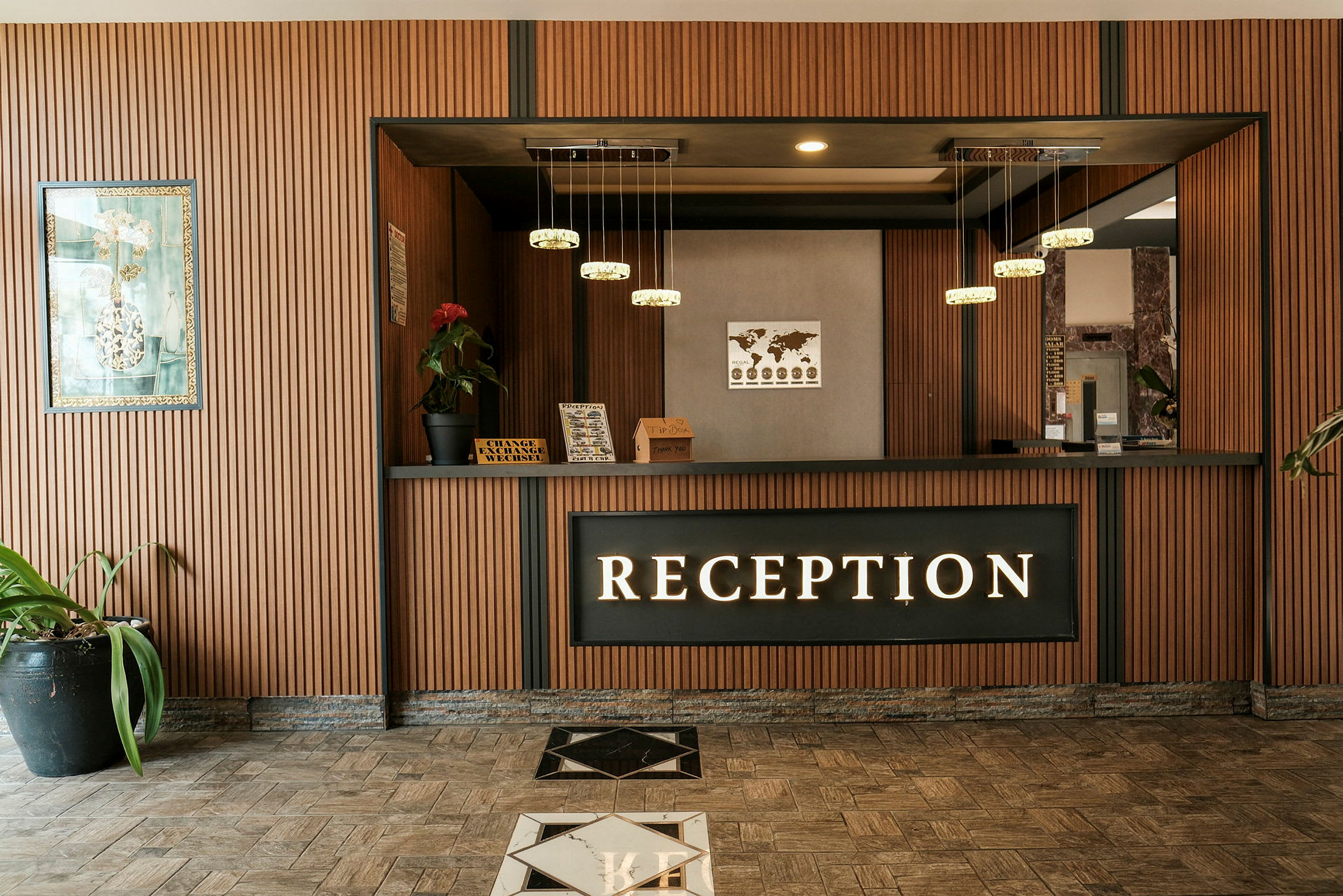 Receptiondisk med träpaneler och hängande lampor. (AI-genererad text)