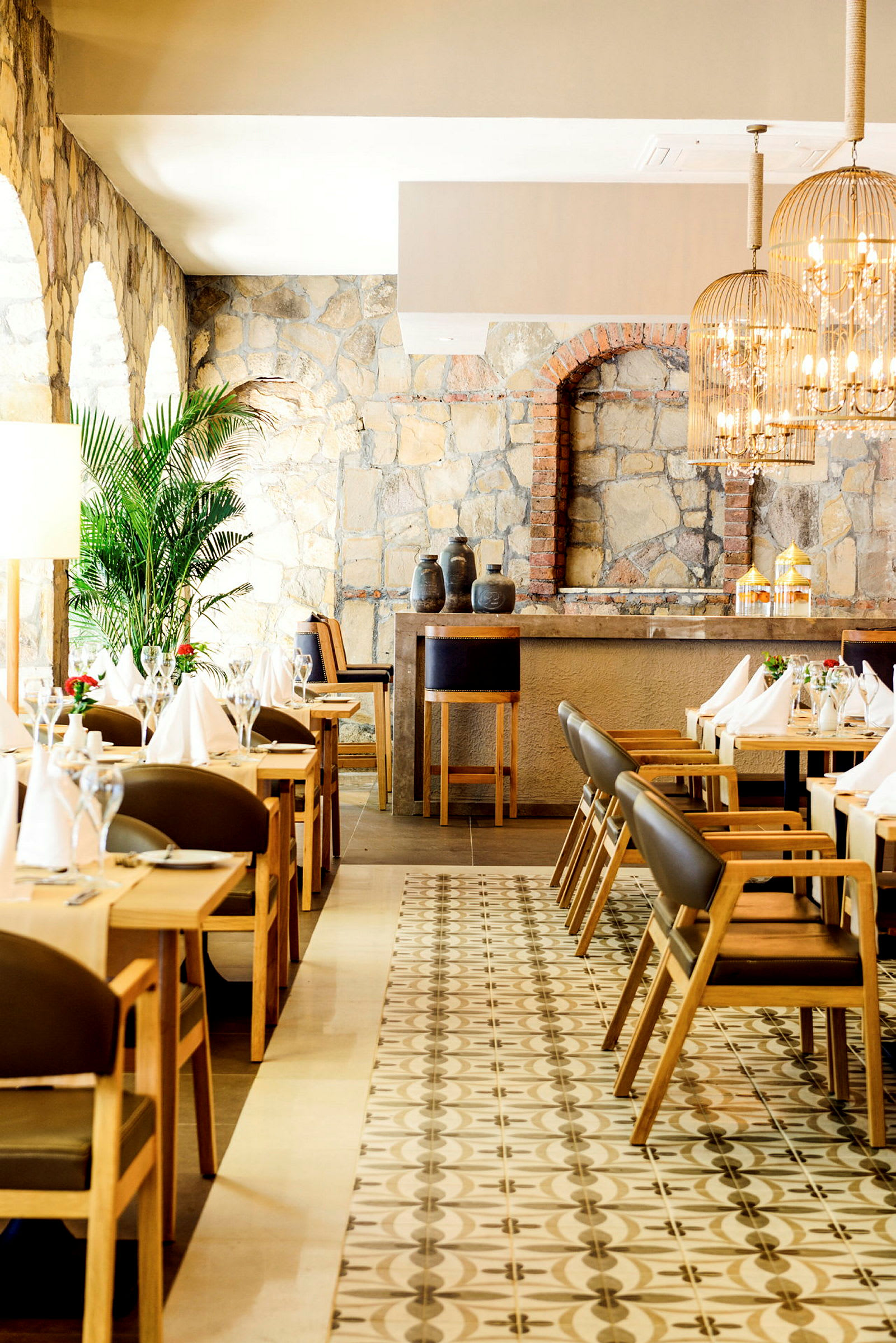 Elegant restauranginteriör med stenmur, trästolar och bord. (AI-genererad text)