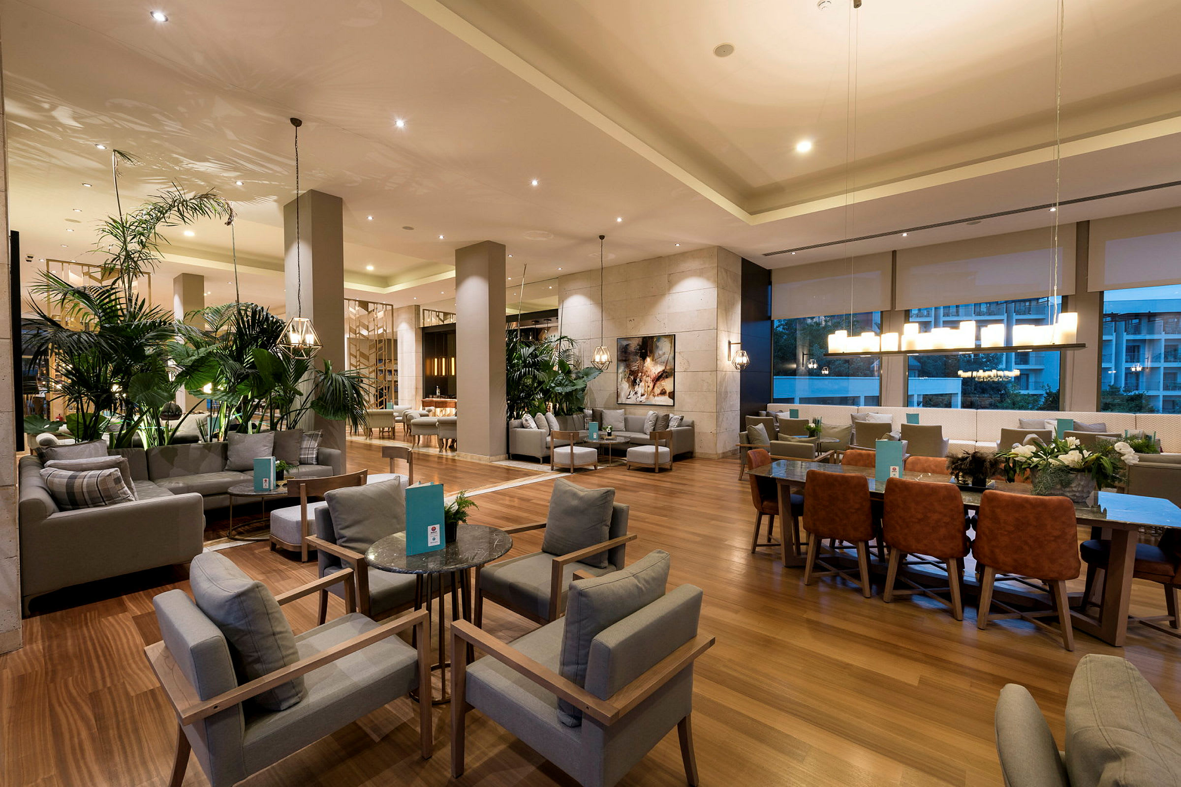 Ett modernt hotellloungeområde med sittgrupper och växter. (AI-genererad text)