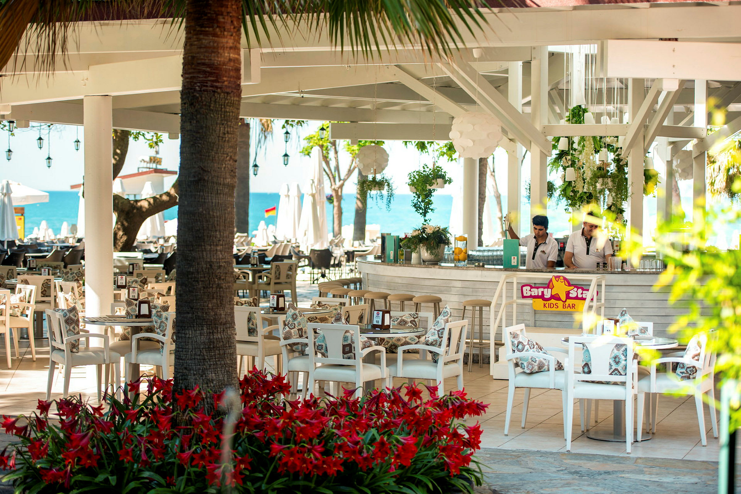 Restaurang med vita möbler nära stranden. (AI-genererad text)